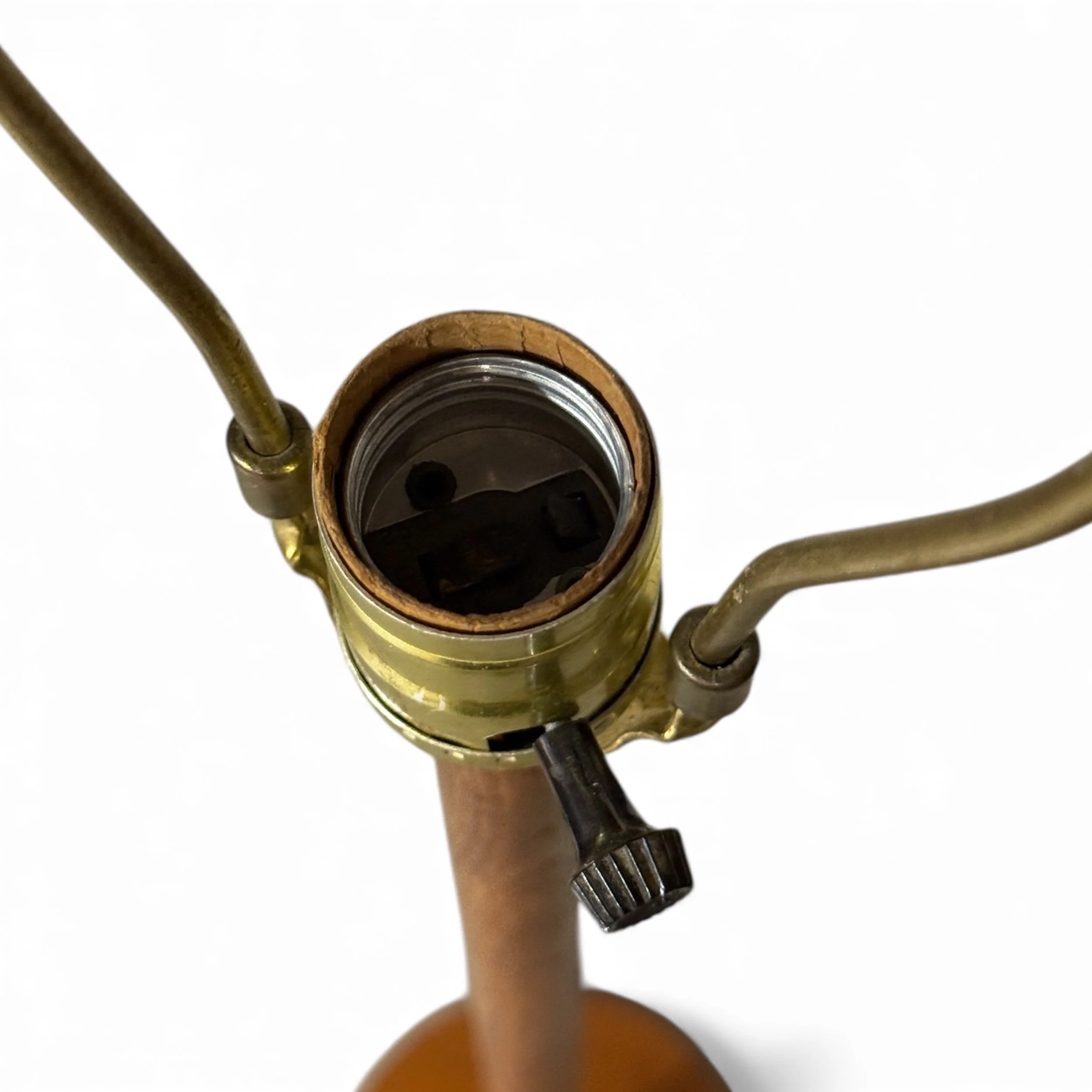 Overhead view of a vintage brass Leviton socket with harp attached to a teak floor lamp