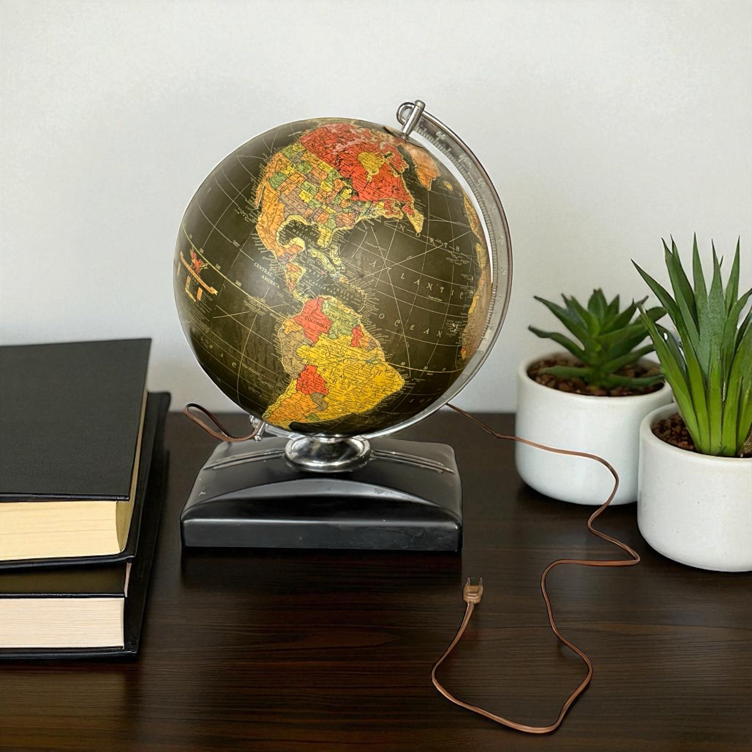 Vintage Replogle Starlight black glass globe light 1950s styled on top of an office desk.