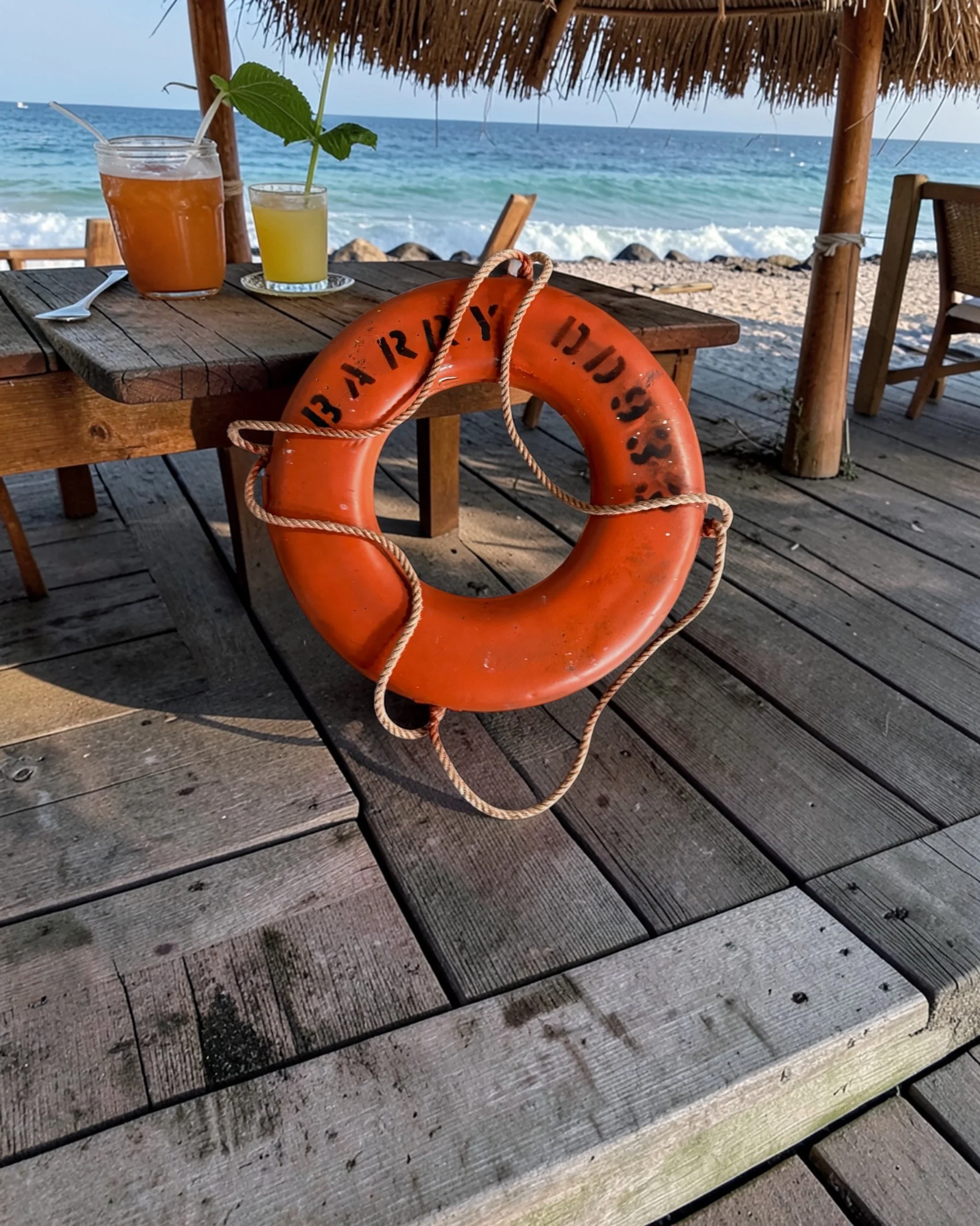 Vintage naval memorabilia USS Barry life preserver used as decor on a beachside restaurant patio
