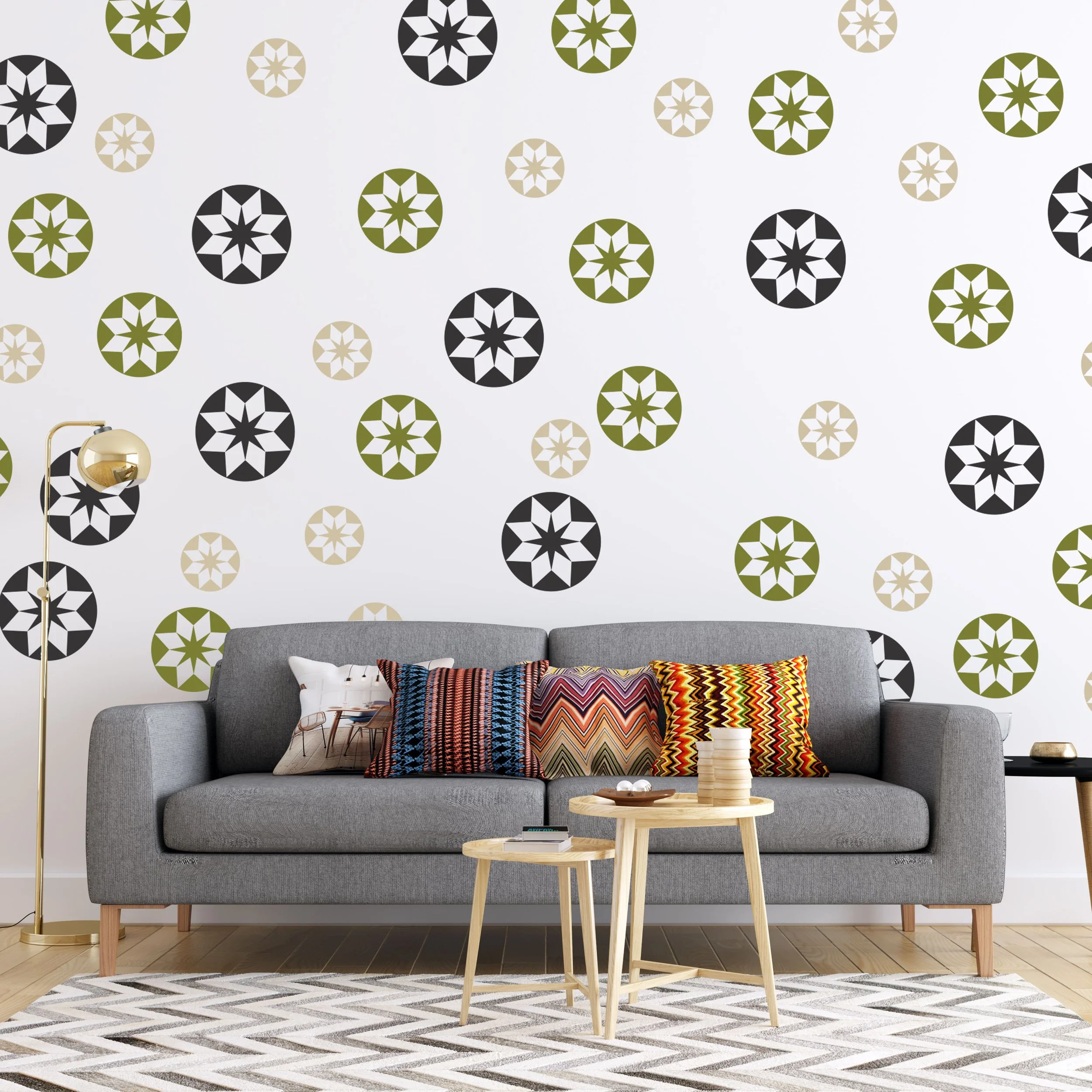 Set of round geometric star quilt pattern wall decals in 3 sizes and 3 colors. Shown in black, olive, and beige on a white wall in a modern living room.