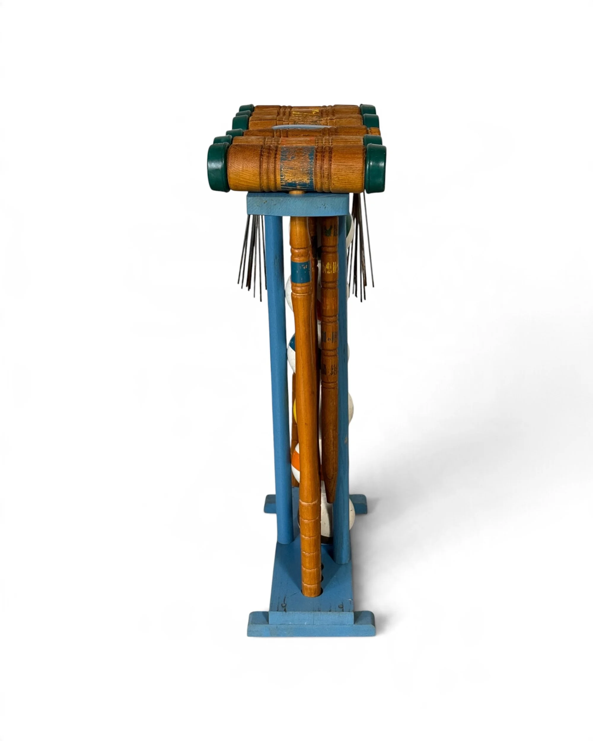 Side view of the vintage croquet set and stand highlighting the overall shape, construction, and included equipment.