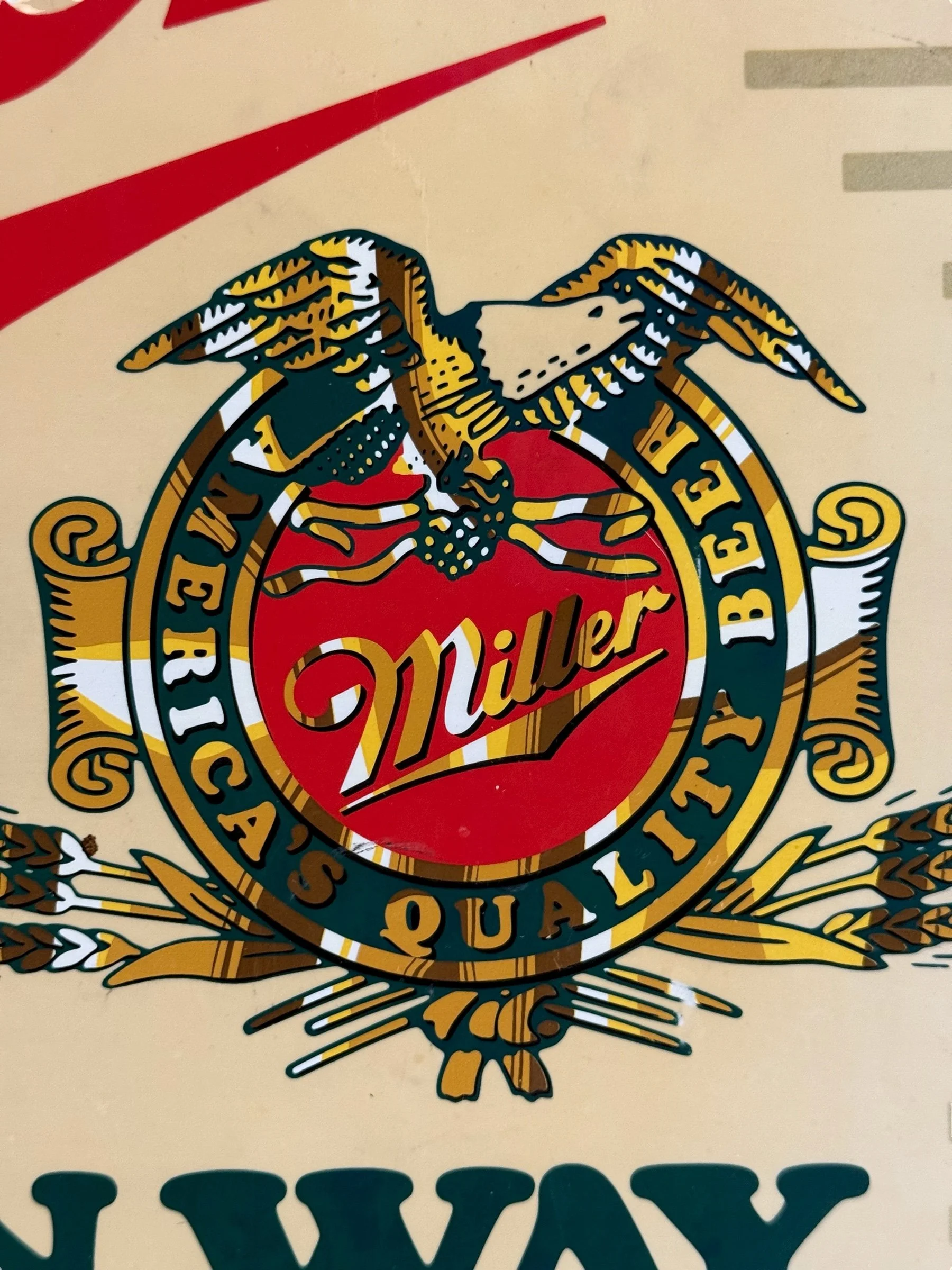 Close-up of Miller logo  with “America Quality Beer” lettering on vintage lighted beer sign.
