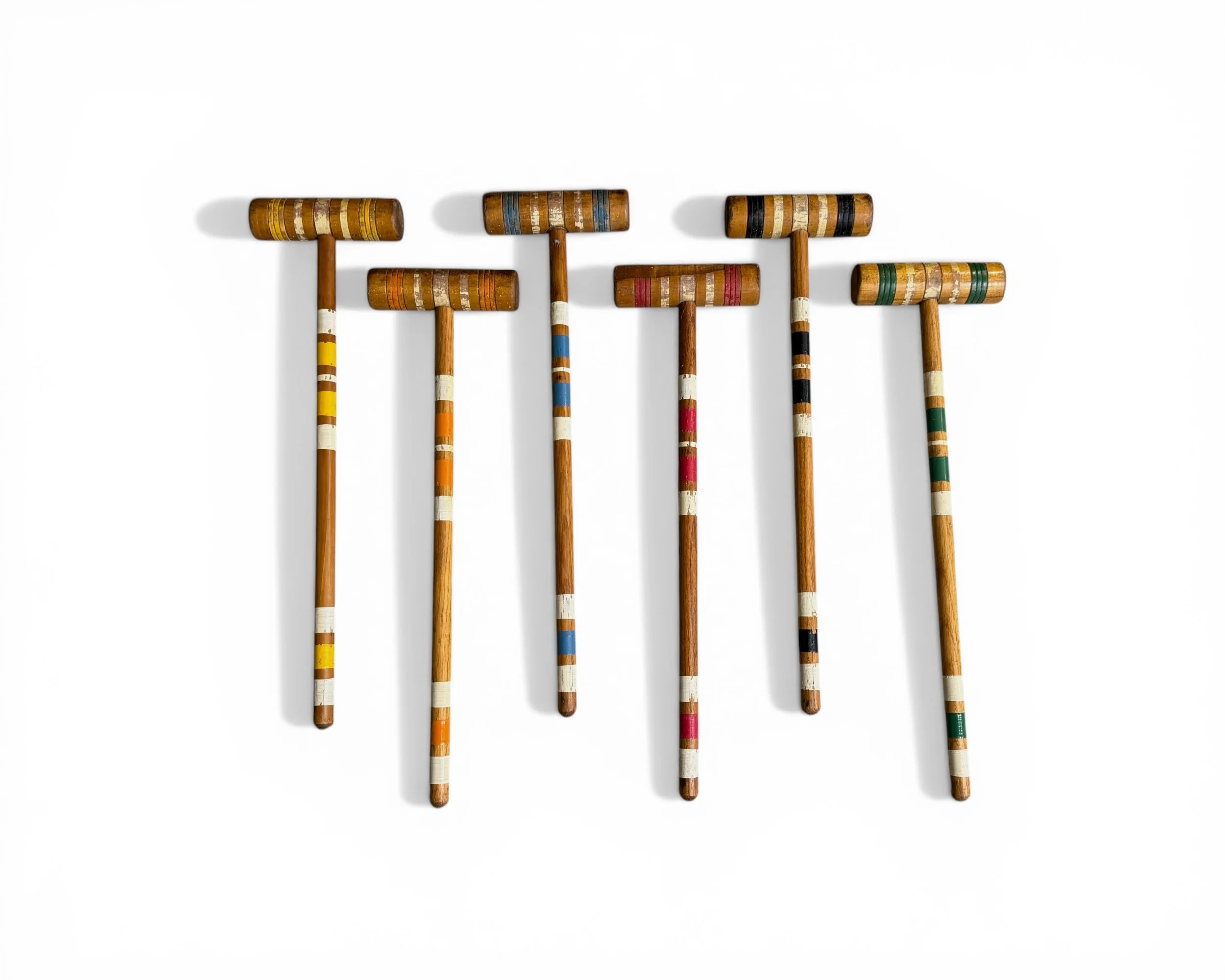 Full view of wooden croquet mallets with colorful stripes