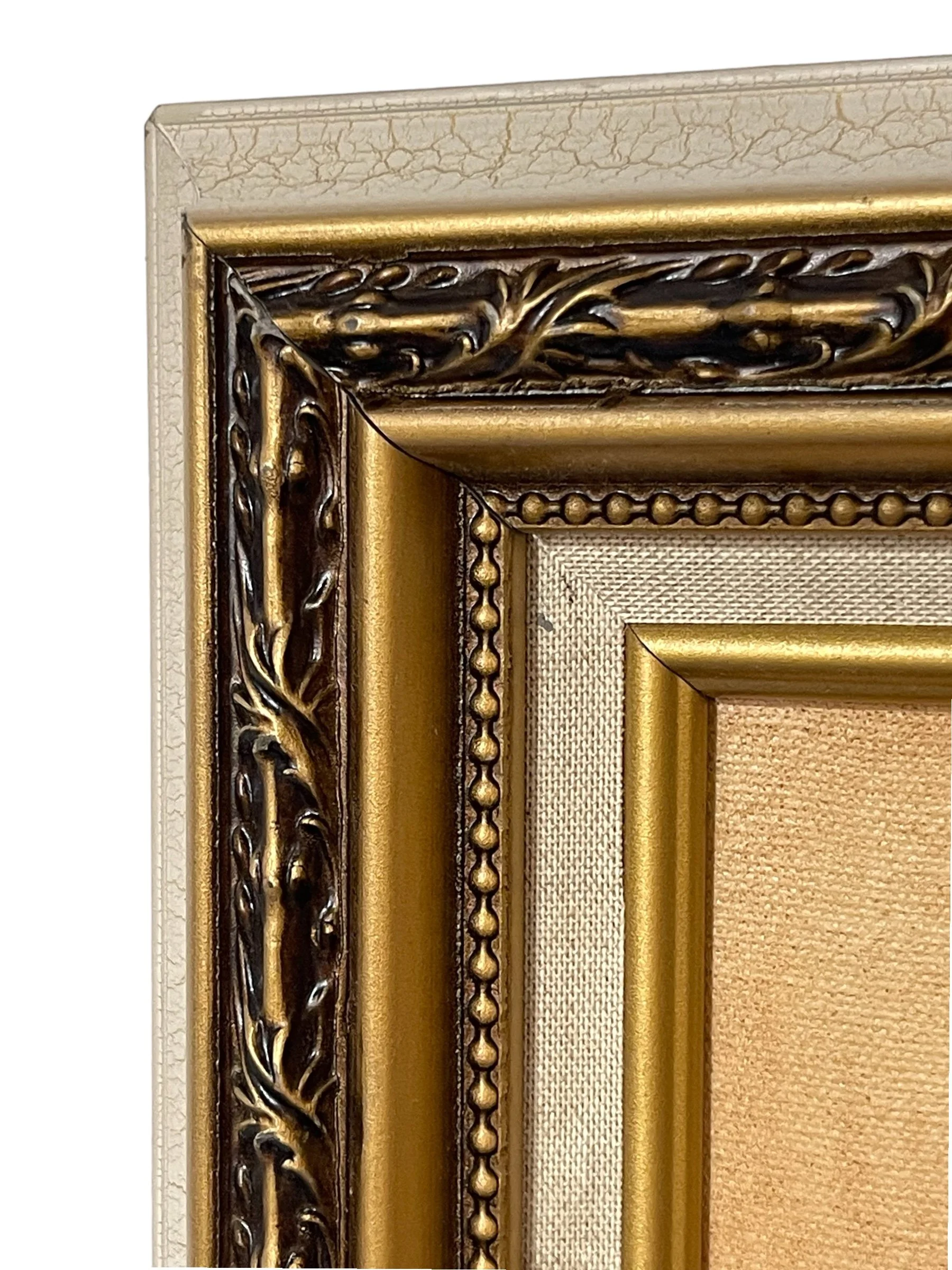 Close up view of the corner of a vintage white and gold ornate frame.