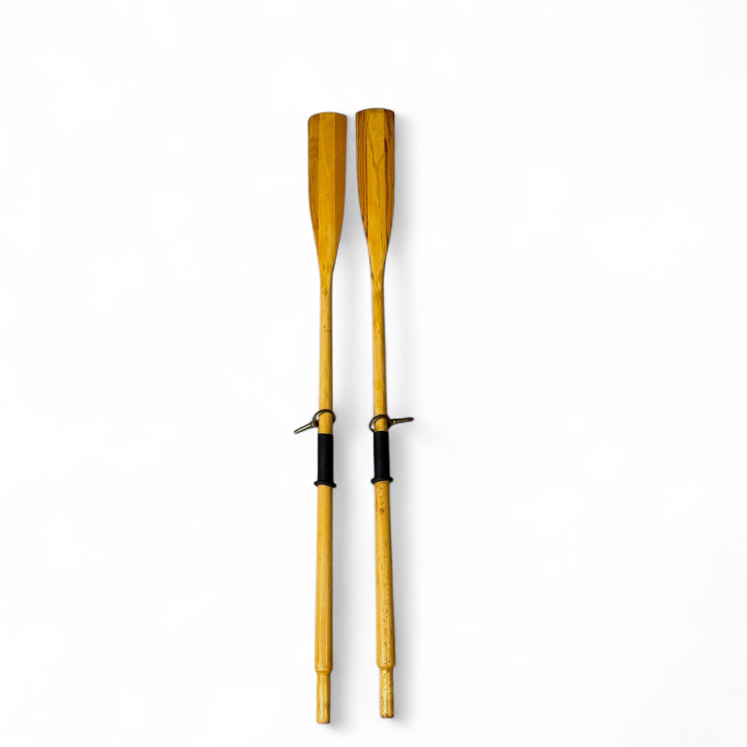 Pair of vintage wooden boat oars with black rubber handle grips and brass oar locks 71 inches long. Beach home or lake house wall art.