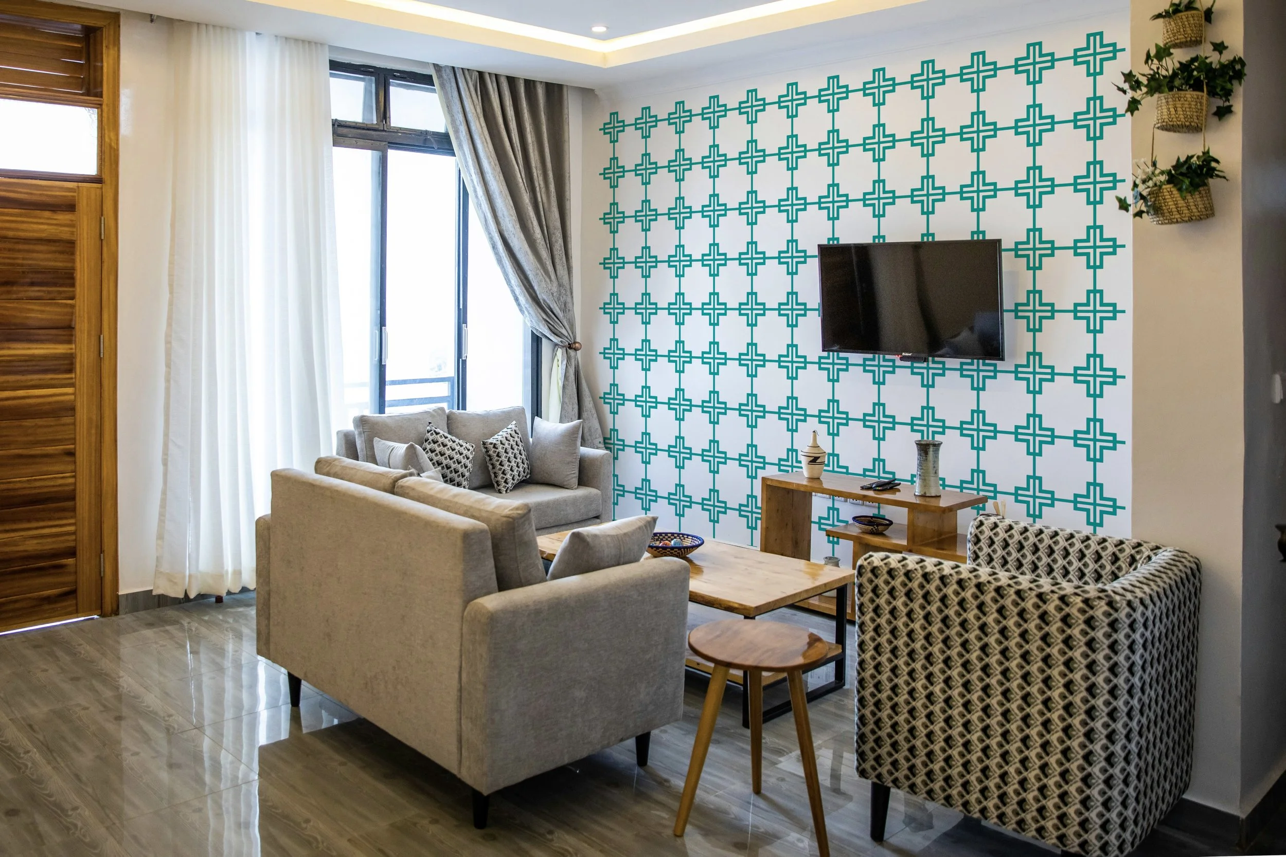 Interlocking swiss cross pattern vinyl wall decal shown in turquoise in modern living room.