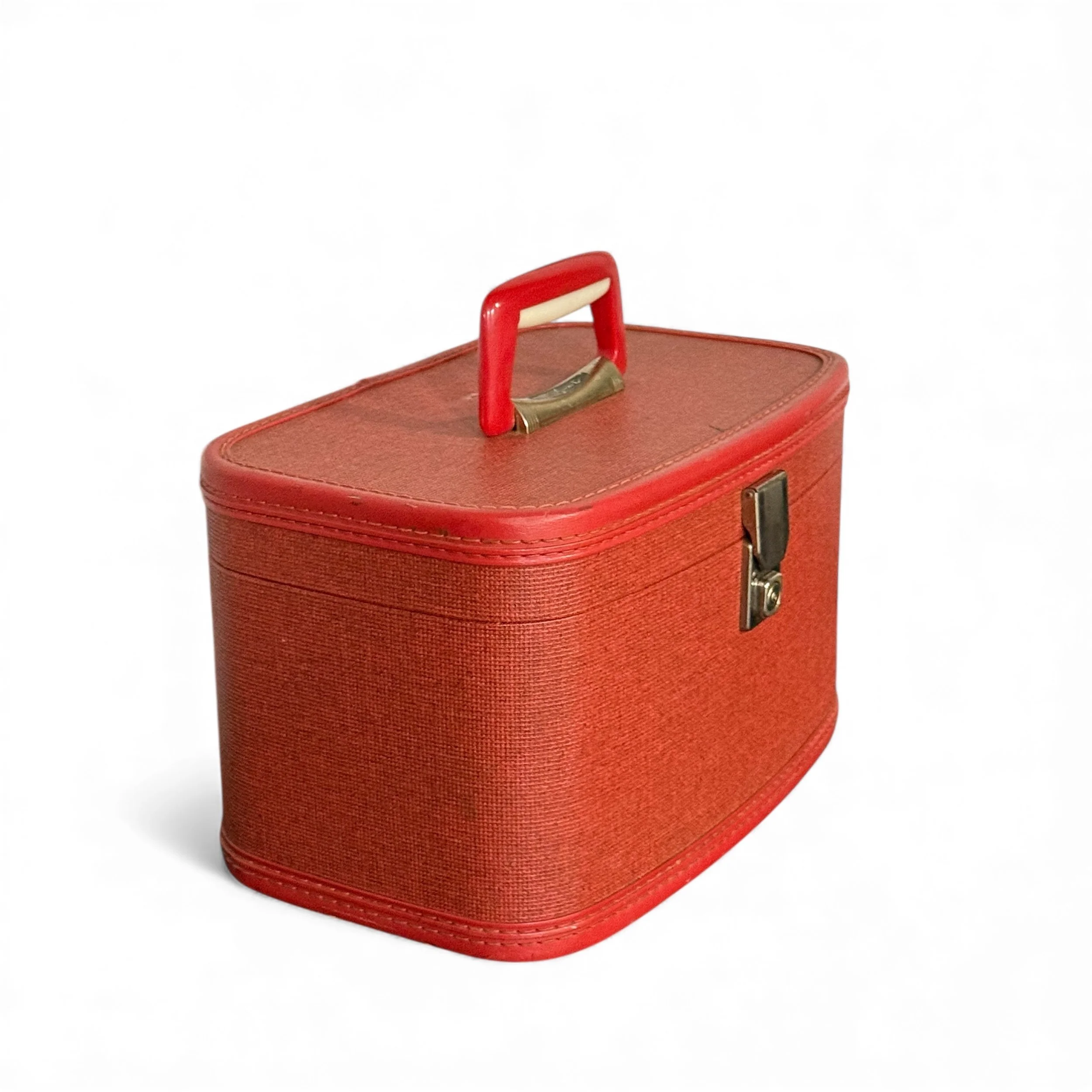 Side view of a red vinyl mid century modern train case in nature lighting on a white background