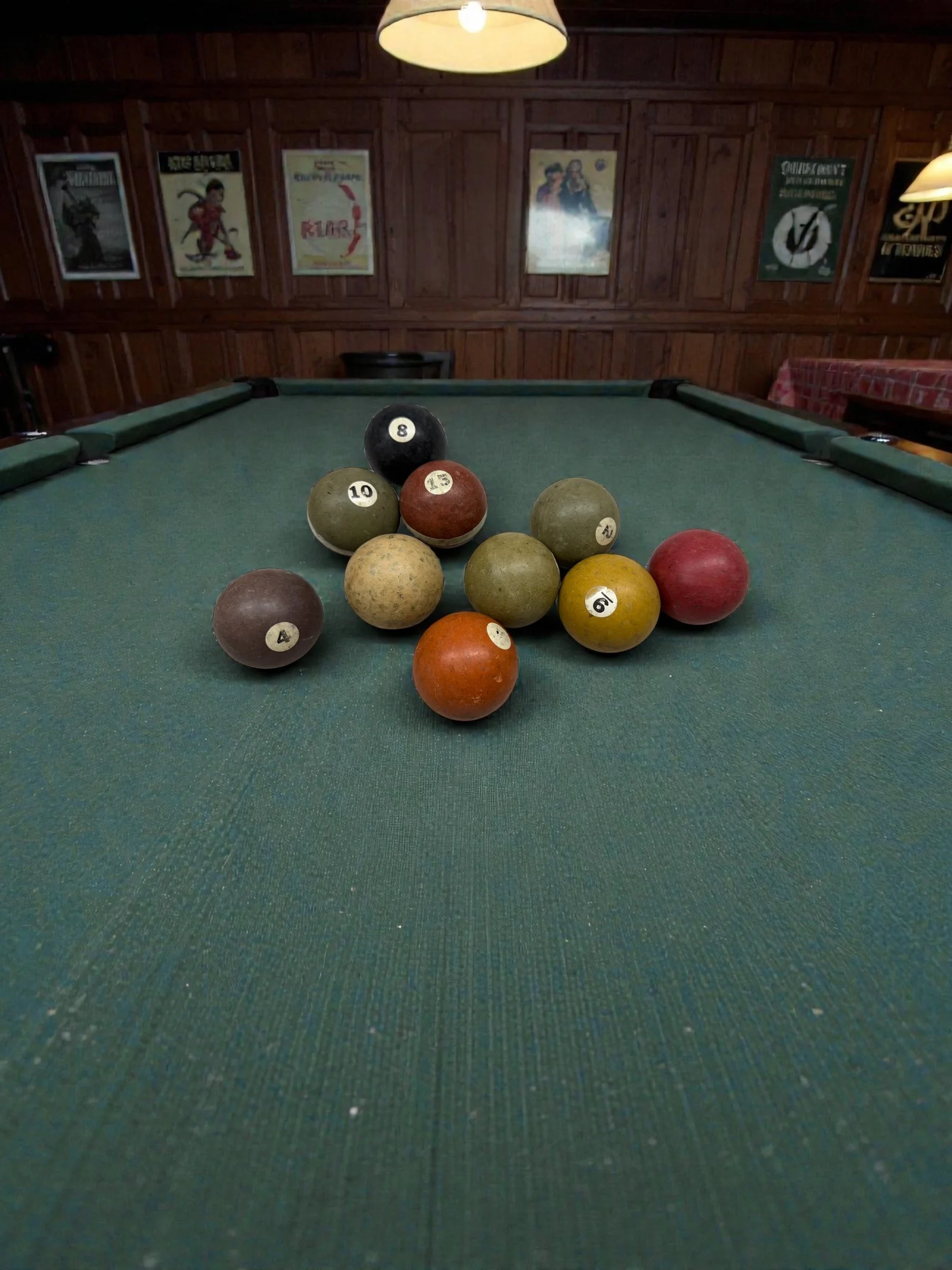 Set of vintage billiard balls displayed for retro game room decor on an old pool table.