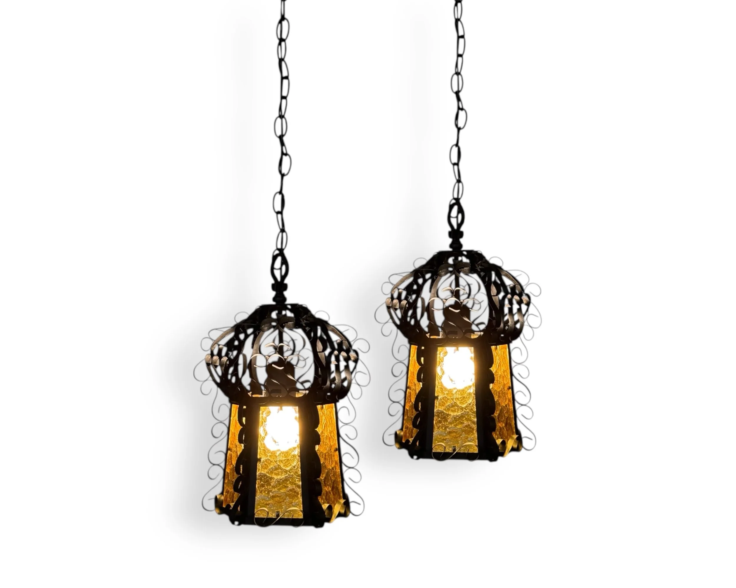 Vintage Spanish Revival hanging swag light pair with wrought iron and amber glass suspended by black chain and cord