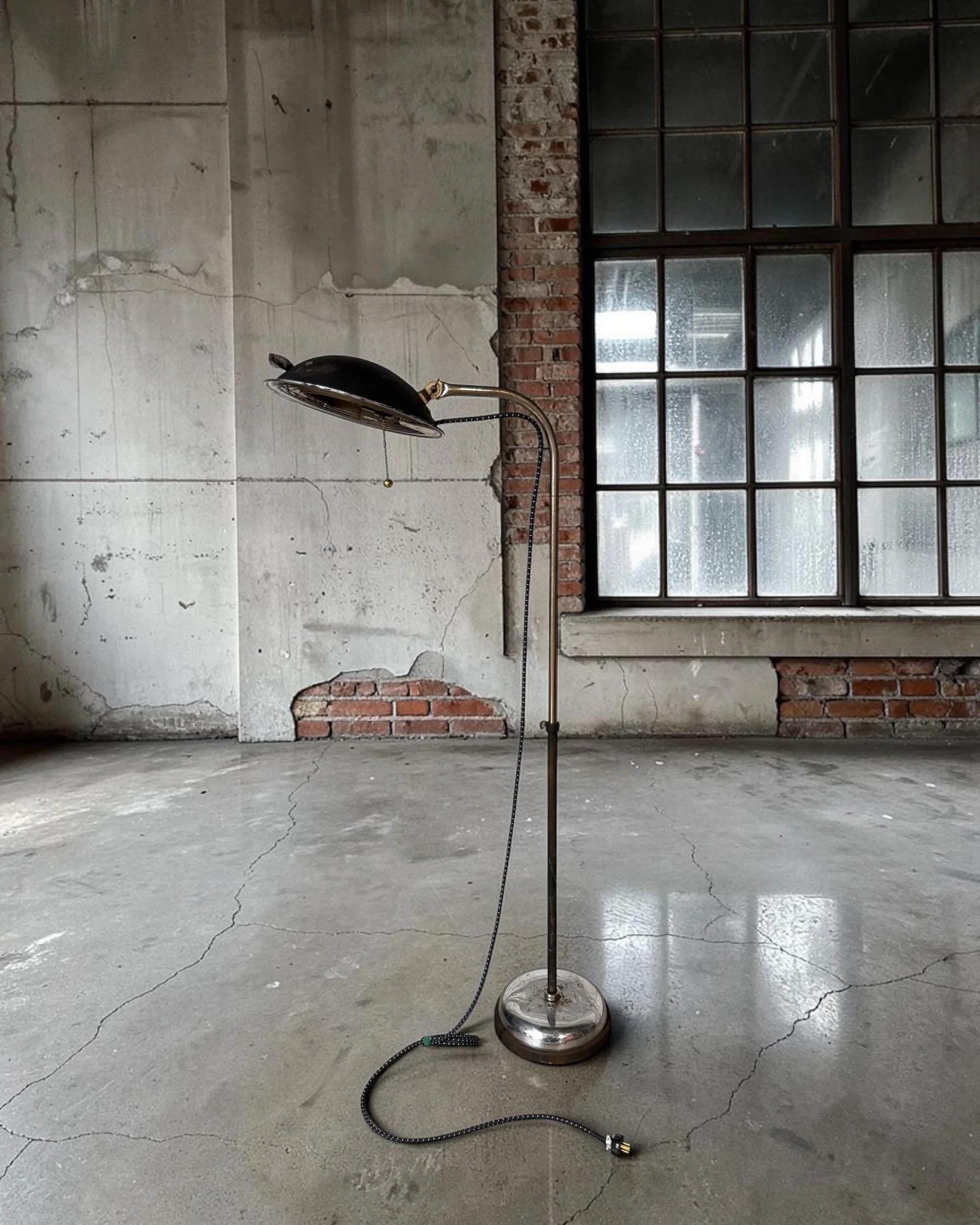 full view of a vintage upcycled heat lamp floor light displayed in an industrial loft