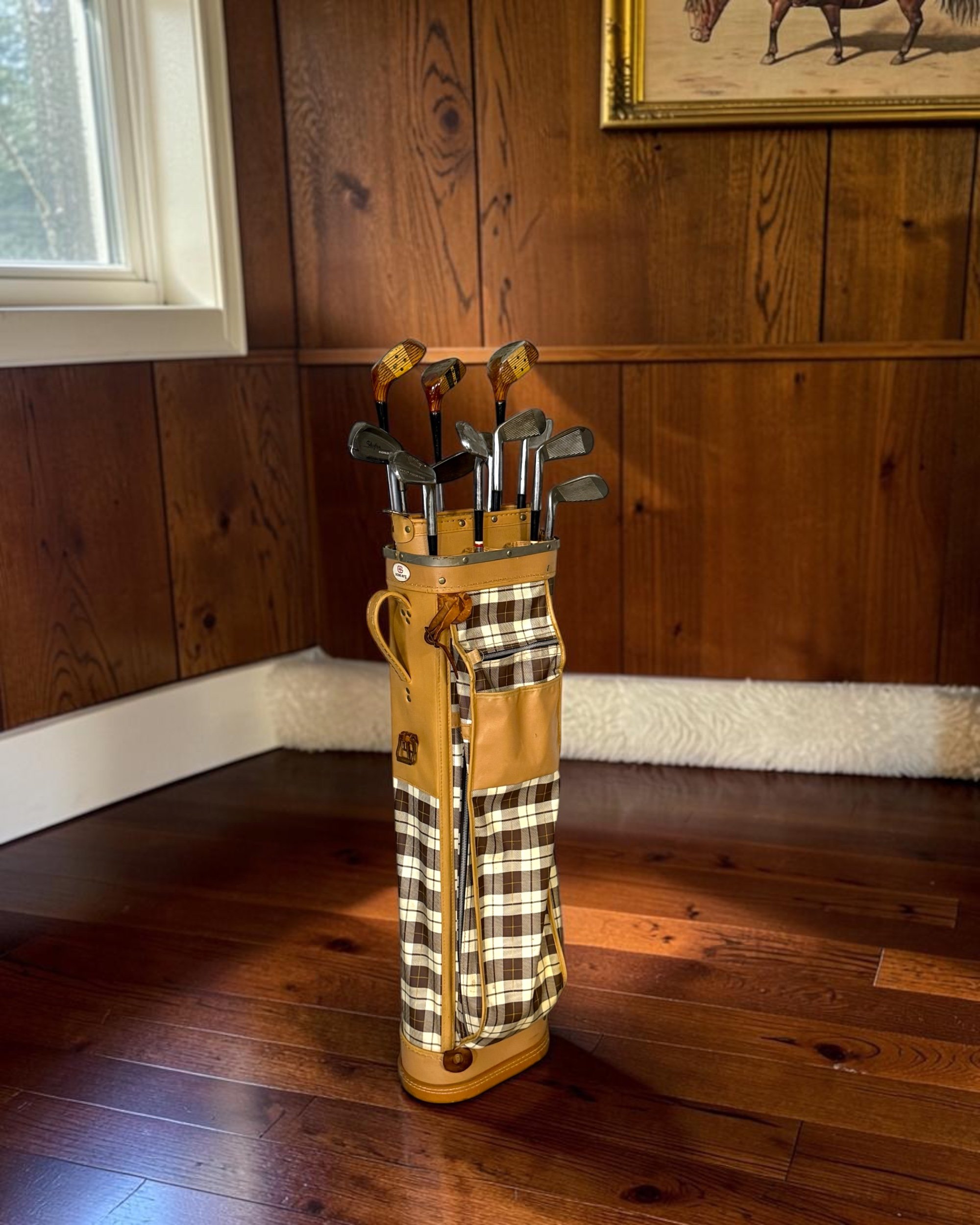 Golf-themed decor display featuring vintage golf clubs and Score-Rite plaid carry bag.