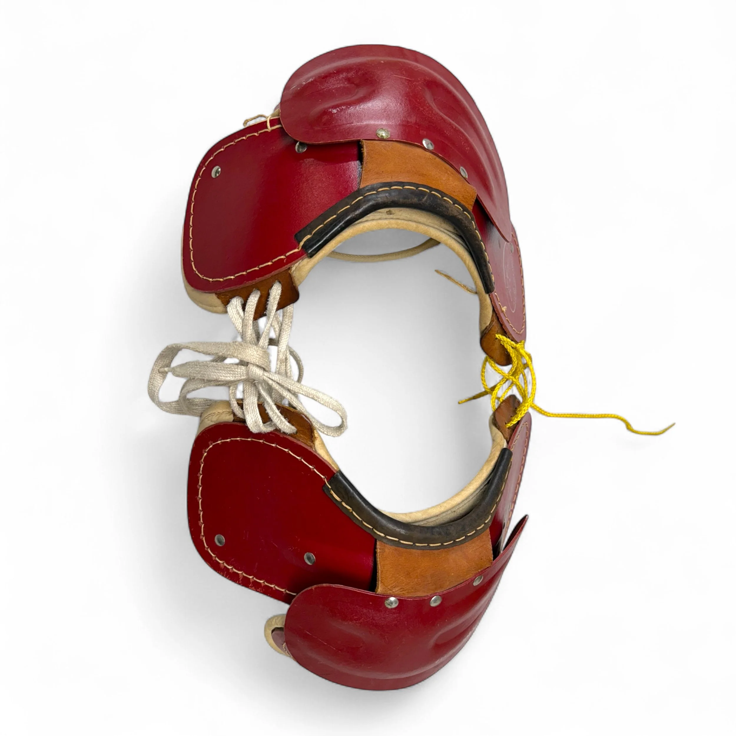 Top view of dark red vintage youth football shoulder pads with yellow and white laces