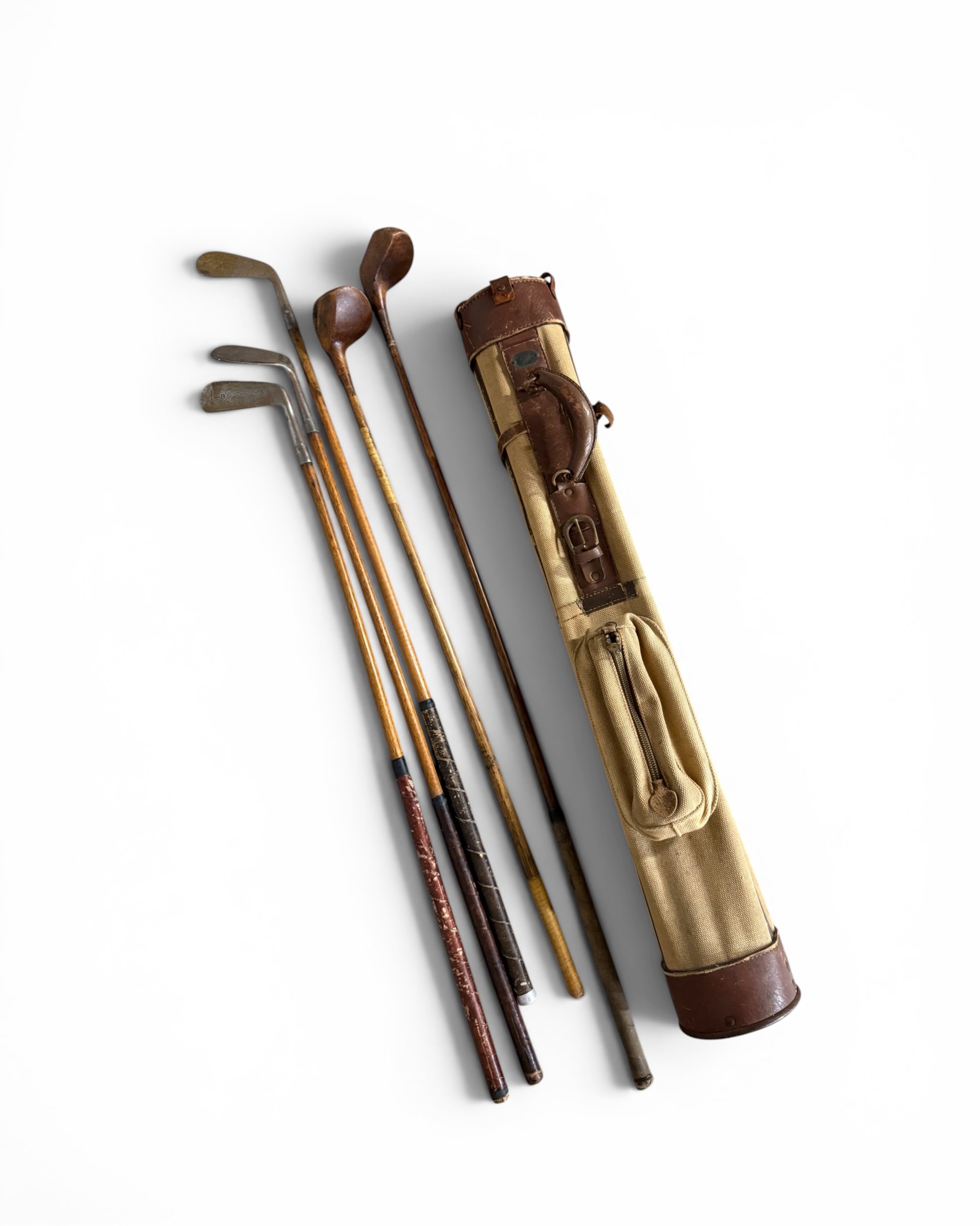 Vintage Allied golf bag with antique Wright Ditson, Wilson, MacGregor and Jack Hutchison golf clubs displayed against a white background.