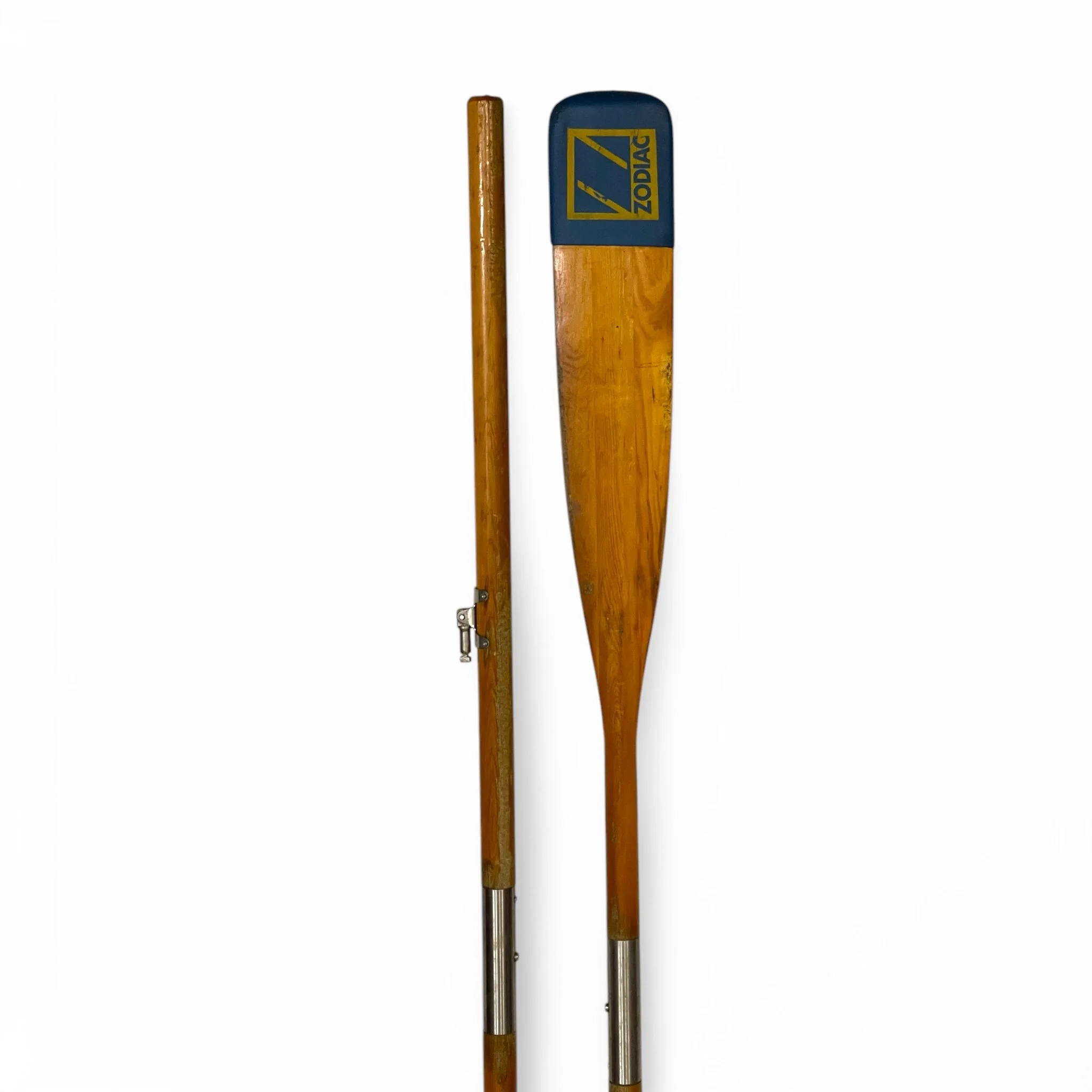 Vintage pair of Zodiac collapsible wooden boat oars, 70.25 inches long. Each oar has blue and yellow wrap with logo prominently displayed. Perfect for practical use or for beach decor.