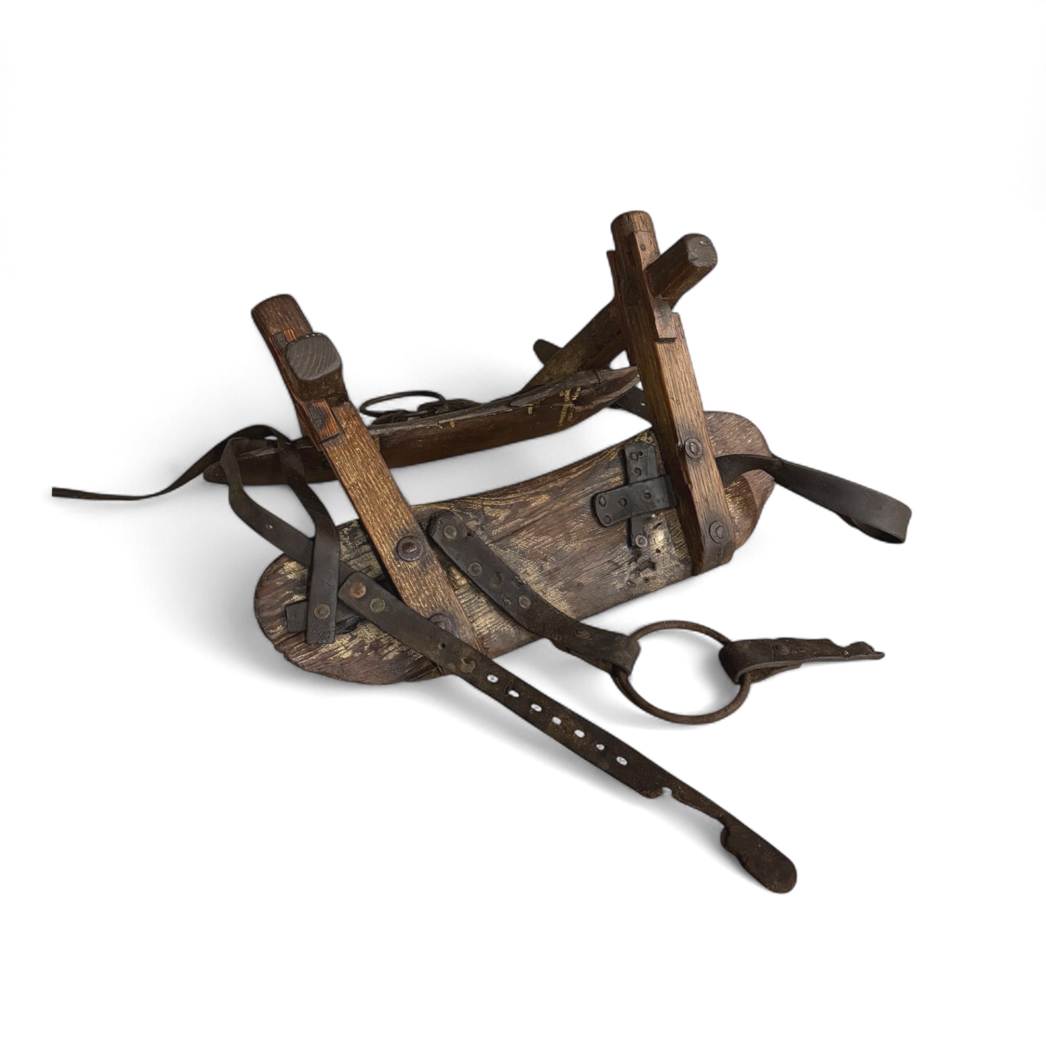 Antique wooden pack saddle with rustic leather straps and metal hardware - vintage equestrian gear for Western decor or collector display.