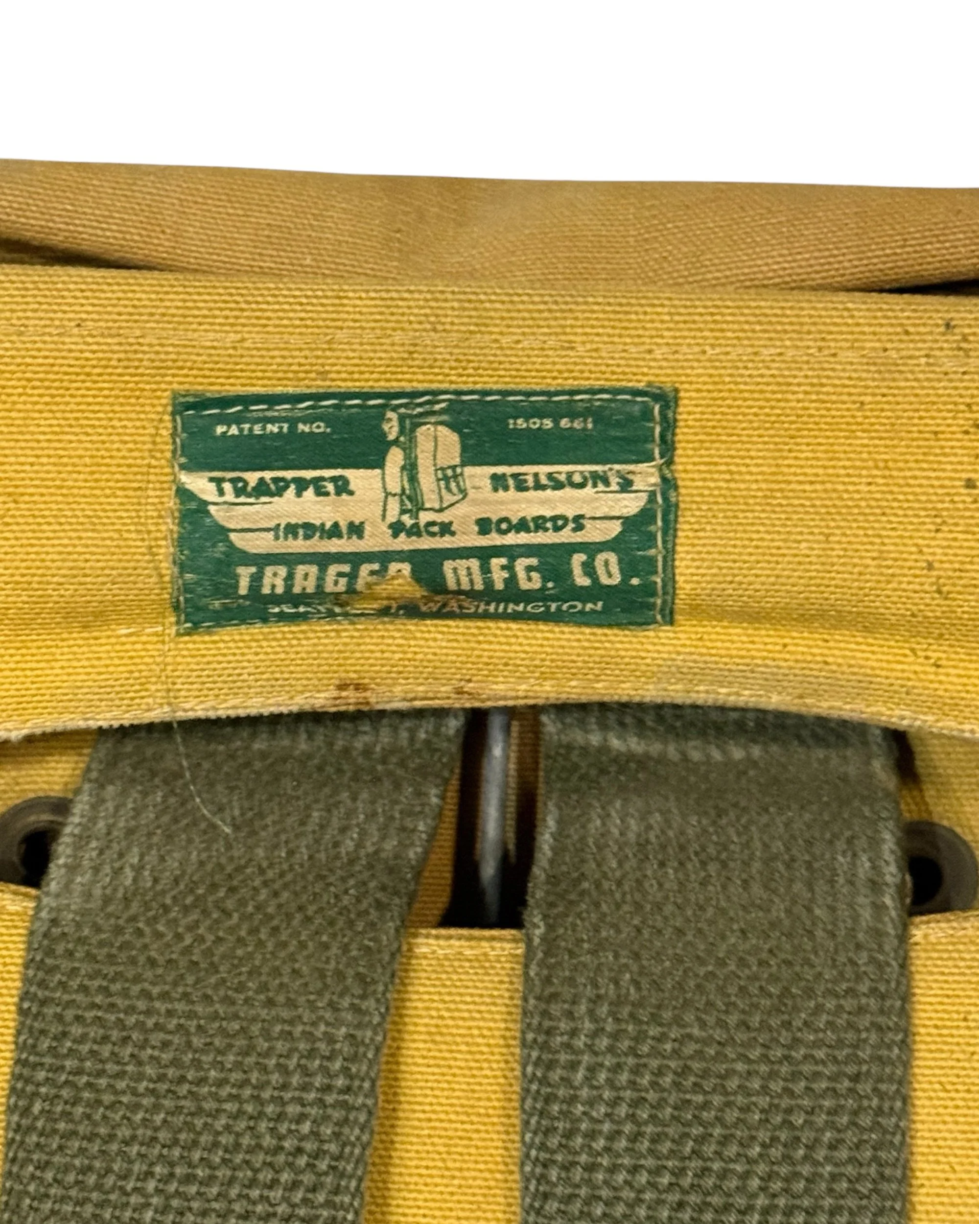 close up view of label on vintage pack board that reads "Trapper Nelson's Indian Pack Boards Trager Mfg. Co., Seattle, Washington"