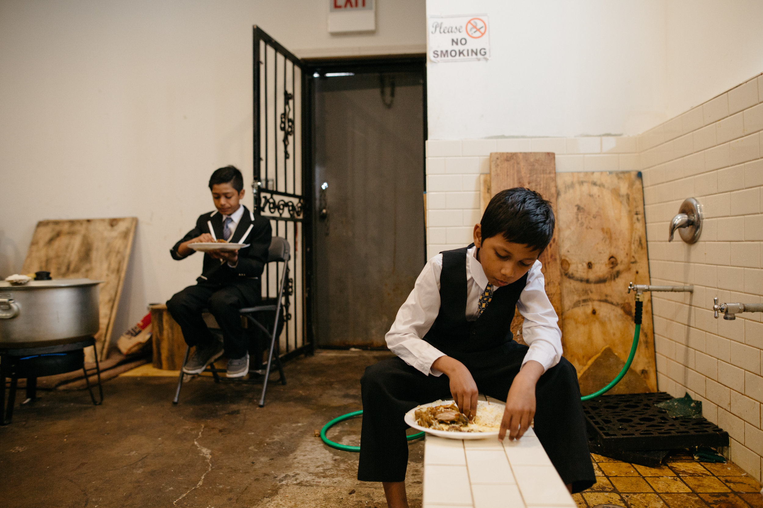 Children enjoying a meal in the back room of the Rohingya Culture Center during its anniversary celebration. The center offers resources for Rohingya new to the area, including English and Islamic classes, and plays host to community dinners and weddings. The center also helps people fill out paperwork, interpret bills and apply for health care coverage, and provides translators.