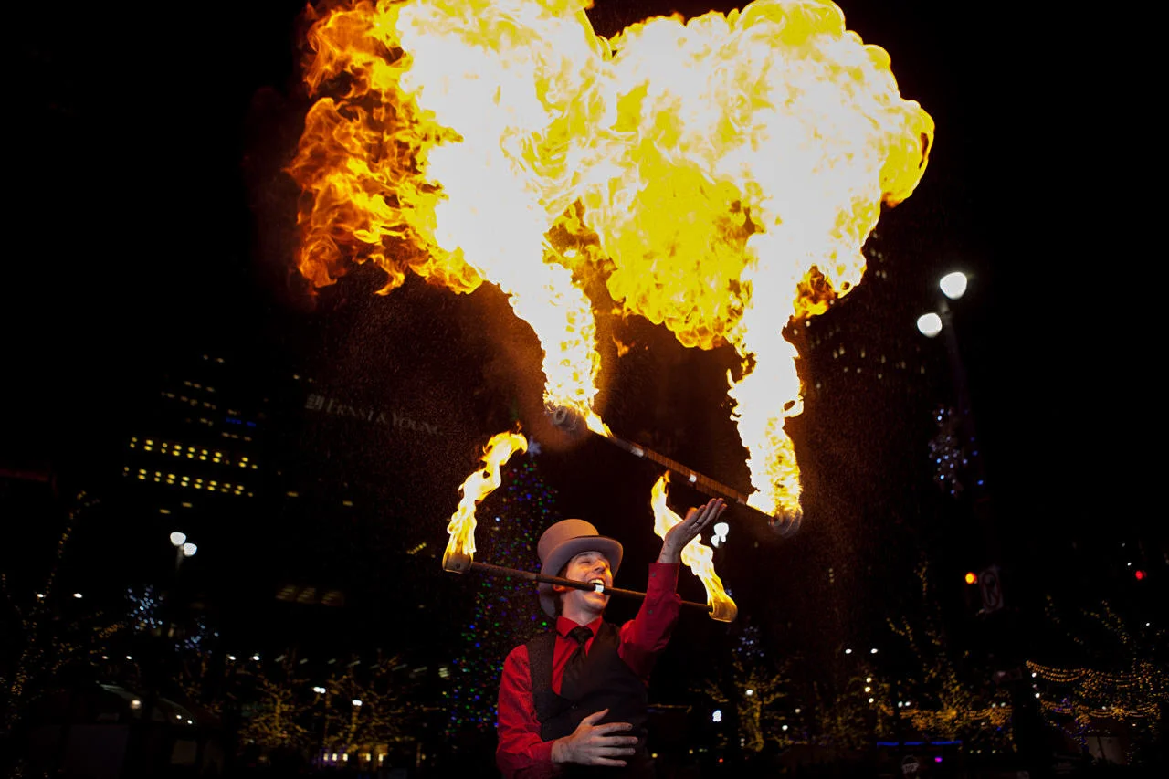 Andrew D’Ascenzo, a performer for Bacchanal Promotions, throws fire at Campus Martius Park.
