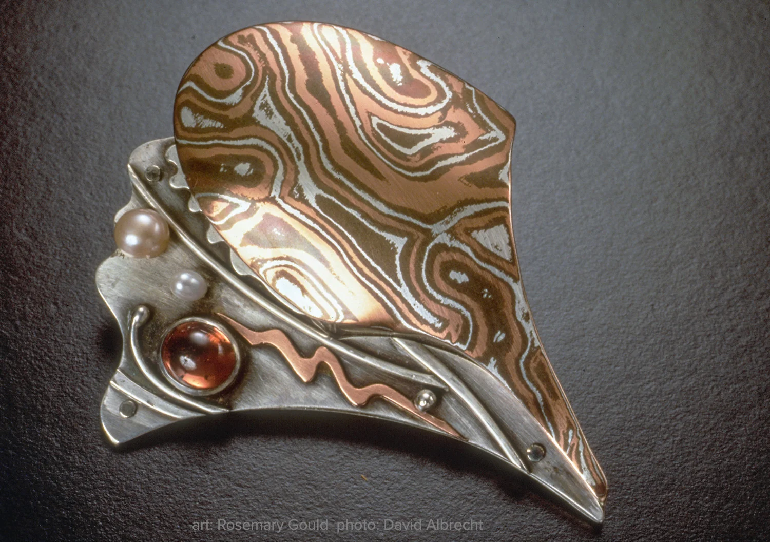 Shell Series Conch Brooch by Rosemary Gould. Shibuichi, copper, and fine silver with pearls and garnet. Photo: David Albrecht