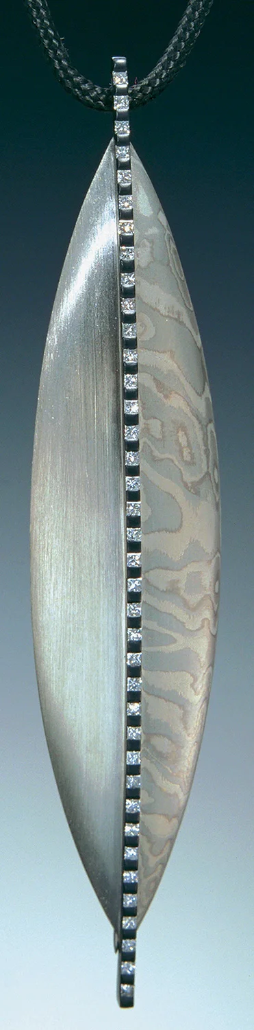 “Shield Series” Pin/Pendant by Steve Midgett. Platinum, shakudo, palladium and silver with diamonds.