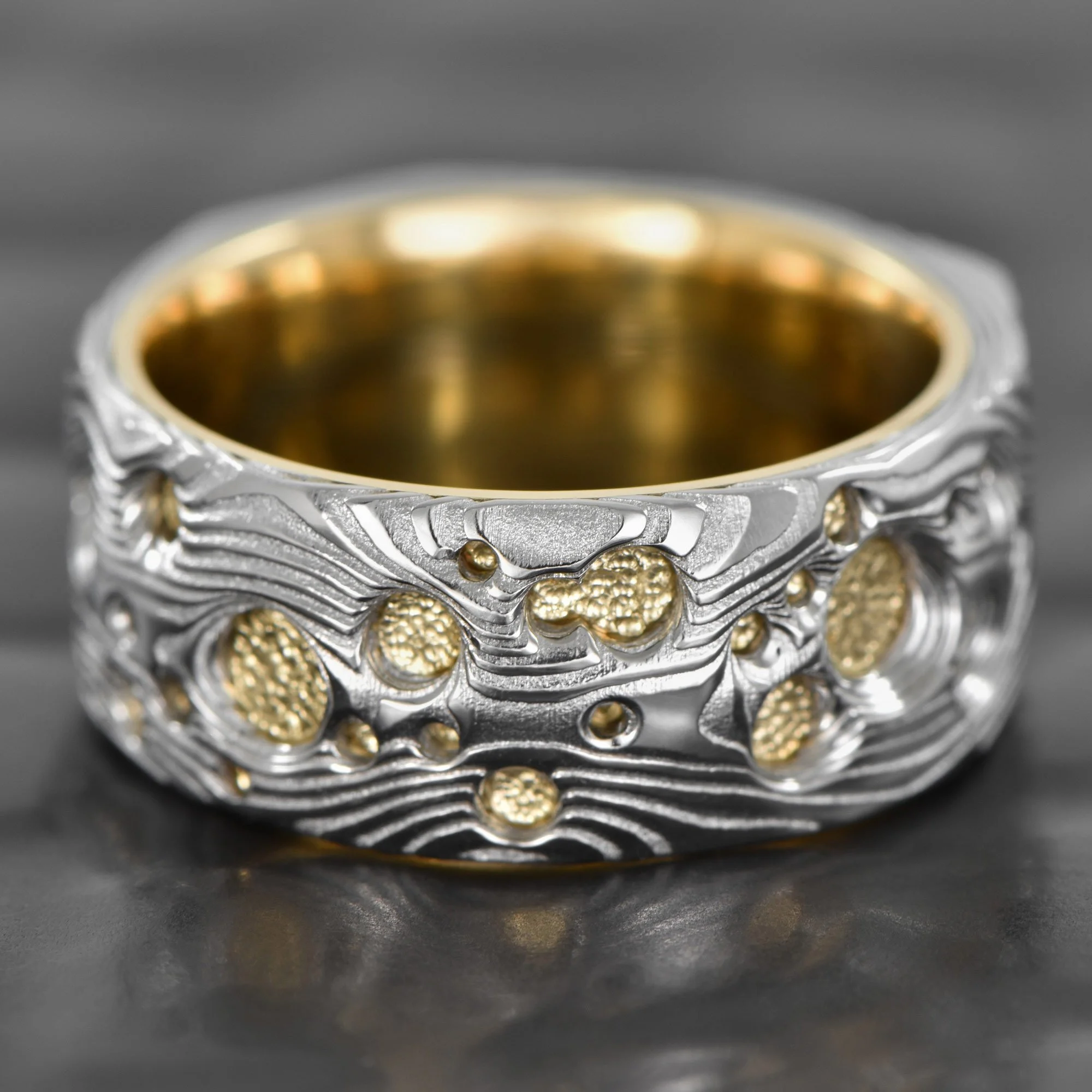 Old-Growth-Damsacus-Steel-Ring-Carved-Crater-18K-Yellow-Gold-Sleeve.jpg