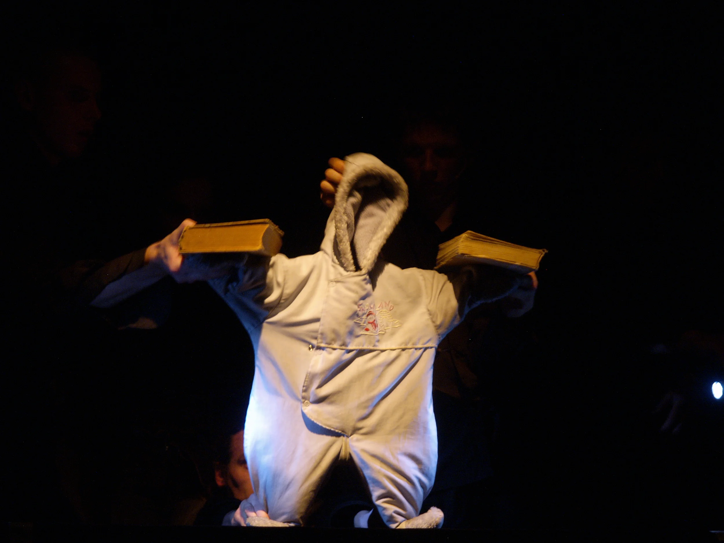 An empty snowsuit is transformed into a contemporary everyman on a dark odyssey through the 20th century. Based on a comic strip, this award-winning collaboration by avant-garde Slovene physical theater troupe Betontanc, Latvian object theater masters Umka. lv, and the Slovene pop-electronic group Silence, Show Your Face! combines puppetry, physical and object theater, and live music for a truly virtuosic performance. Photo Credit: Gints Malderis