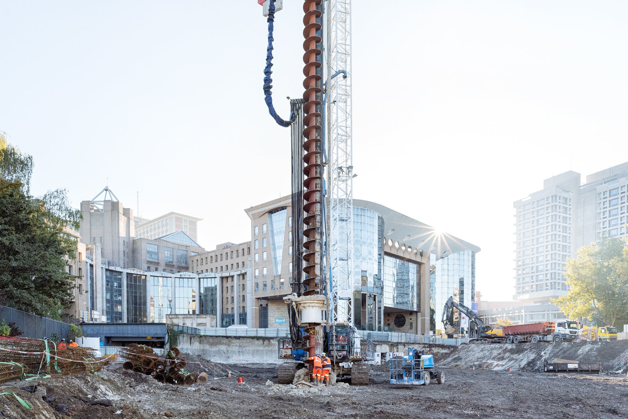 Photographie de suivi de chantier, vue de face d'un engin de chantier creusant les fondations de FORUM, siège du Département à Lille dans les Hauts de France