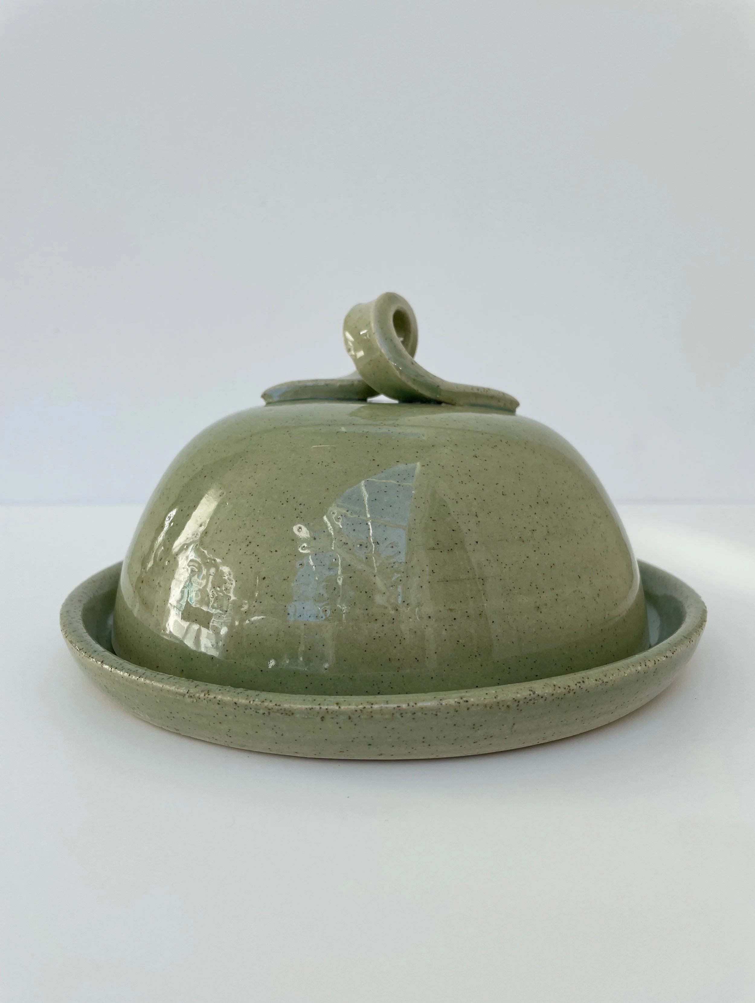 Round ceramic butter dish with croissant-shaped handle and lid