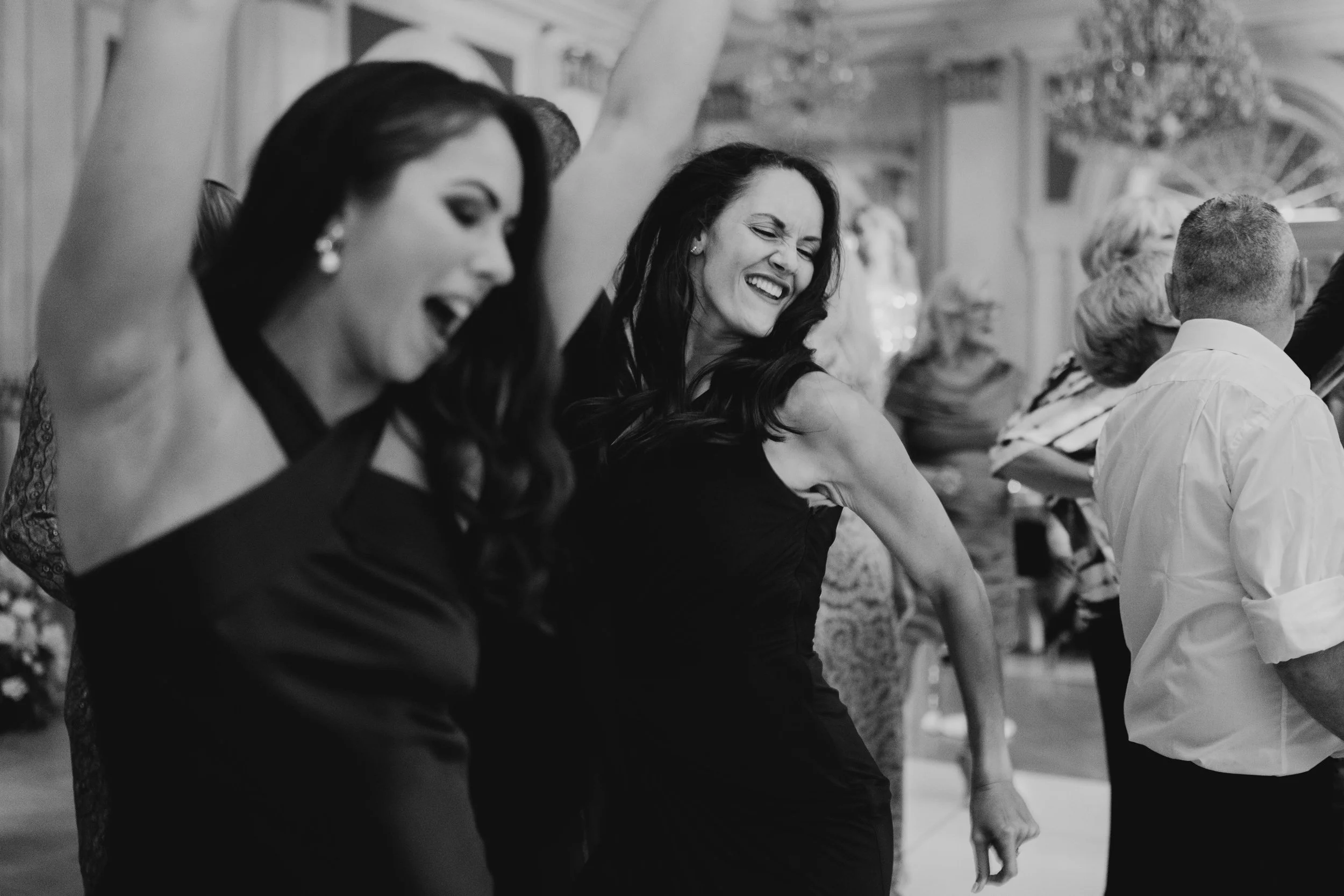 Black and white photo of people dancing and having fun at a party or celebration.