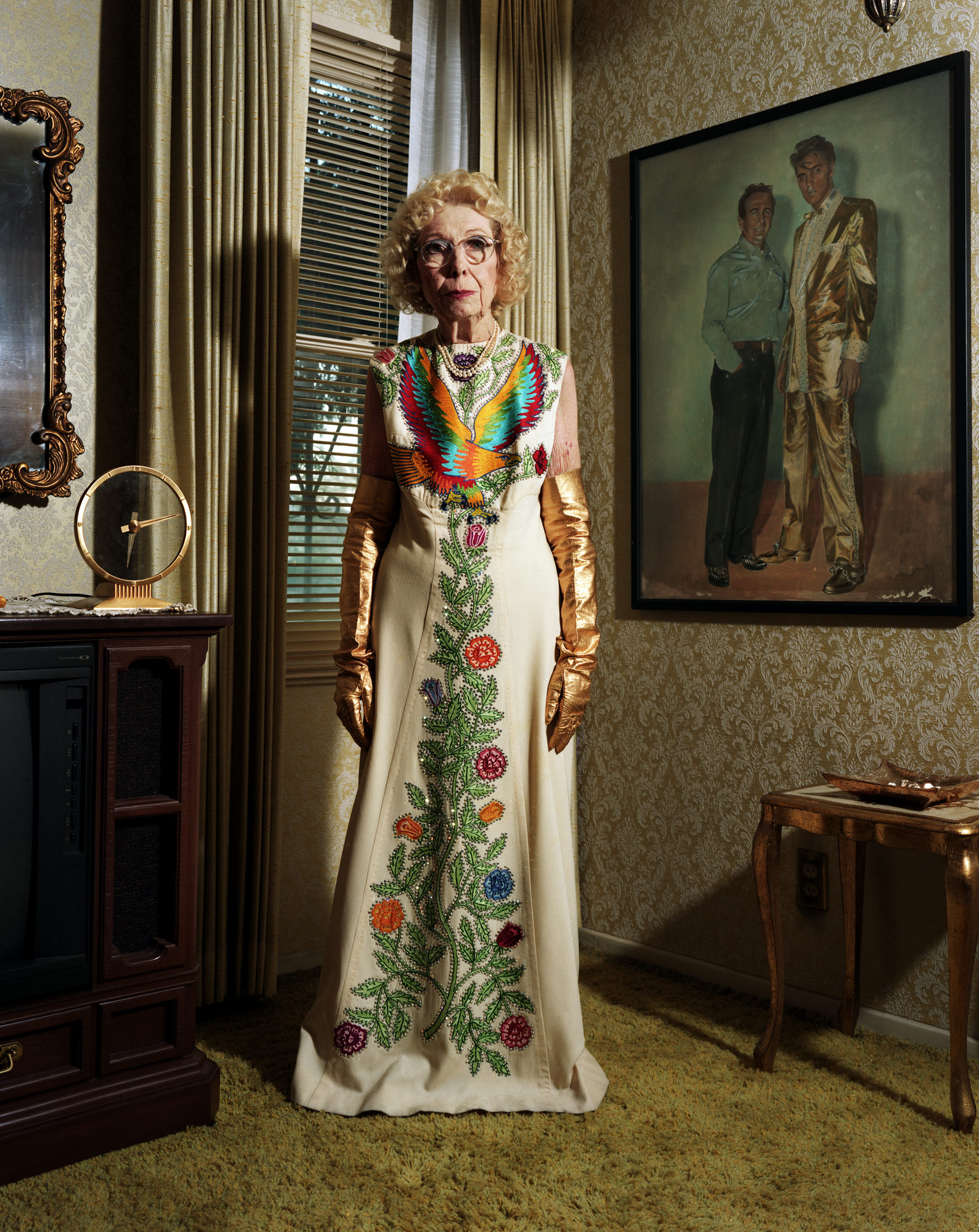 Bobbie Nudie - standing with portrait of her late husband Nudie and Elvis, wearing his famed Nudie designed gold lame suit - Arleta, CA