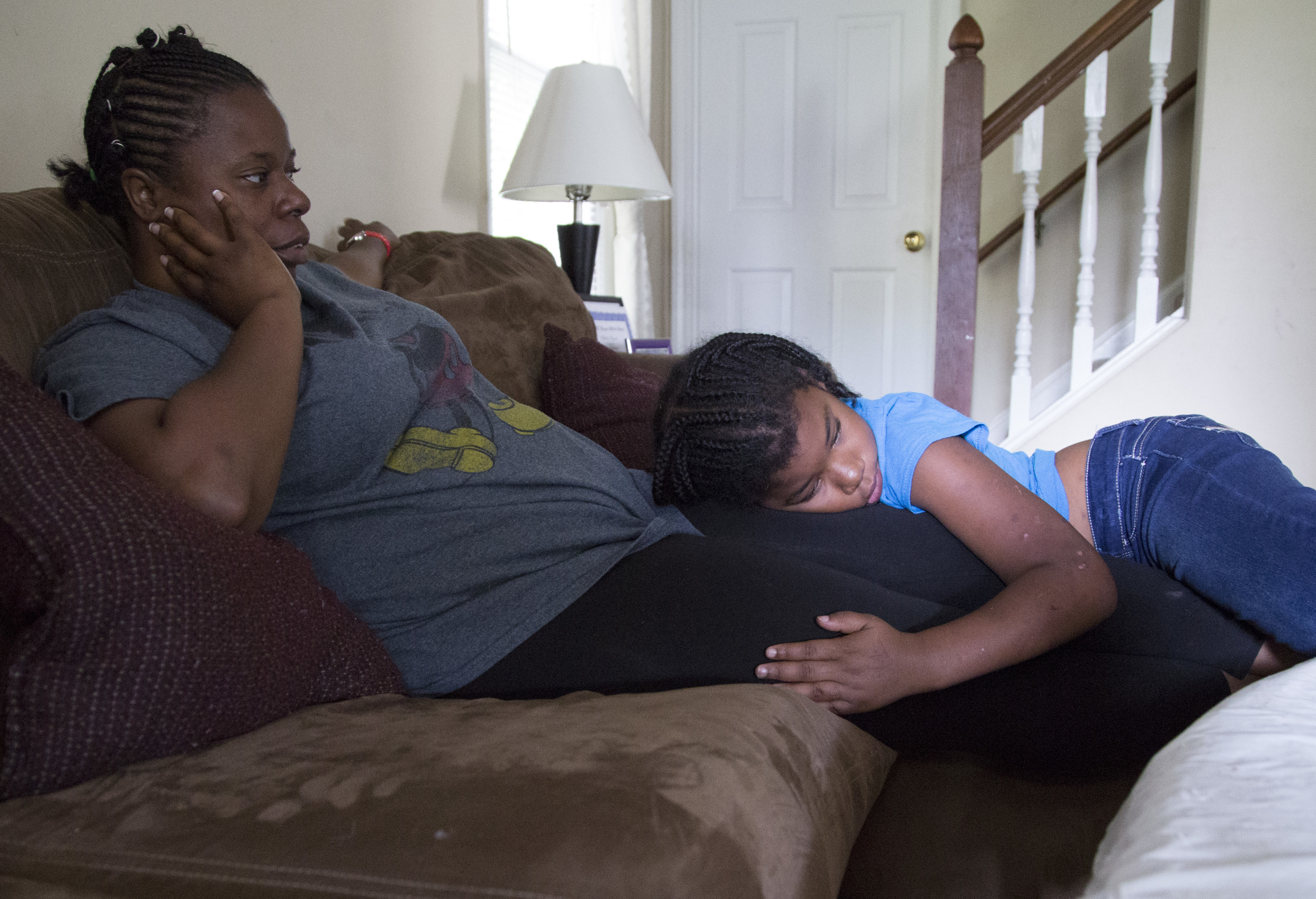 Wednesday: McKenzie Patterson, 8, rests on her mother Monica Alexander's lap while watching her older brothers play video games in Zebulon, N.C., on Wednesday, July 23, 2014. Alexander works part time as a certified nursing assistant but wishes to work full time to support her three children still living at home.