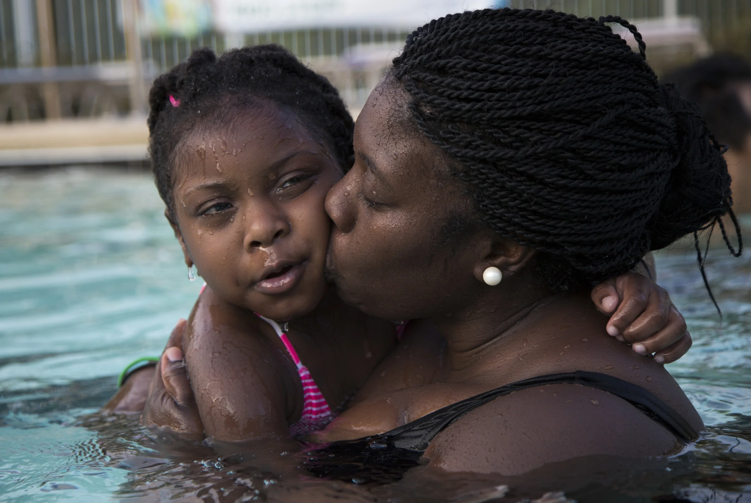 Wednesday: Dawn Dudley kisses her daughter Trinity Dudley, 5, during a swim lesson at the YMCA at Meadowmont in Chapel Hill on Wednesday, July 23, 2014. At age 2 and a half, Trinity was diagnosed with autism which led Dudley to found My Circle of Girls, a social & service group for girls ages 2 to 6 living with autism in the Triangle area. The group offers monthly programming that allows the girls and parents to learn and interact. In July, My Circle of Girls partnered with the YMCA at Meadowmont and their "We Build People" campaign to offer discounted swim lessons for young girls with autism. According to the National Autism Association, accidental drowning accounted for 91 percent of deaths of children with autism spectrum disorders in 2011. "We may have future Olympic swimmers in the group," Dudley said. "But our main goal is teach our girls how to be safe around water."