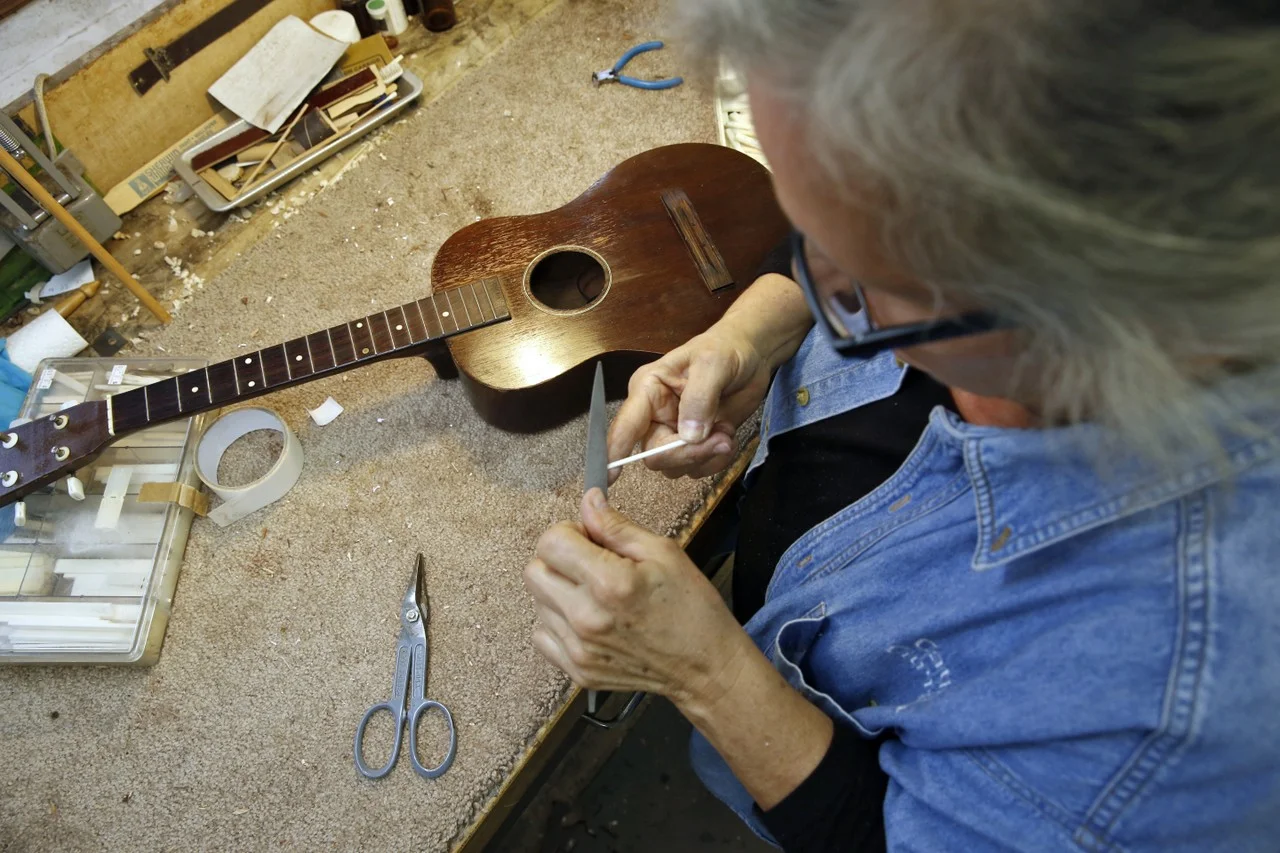  Cathy files a bone to be used in a ukulele repair. She is an expert in all kinds of instrument repairs, from simple to very complicated. 