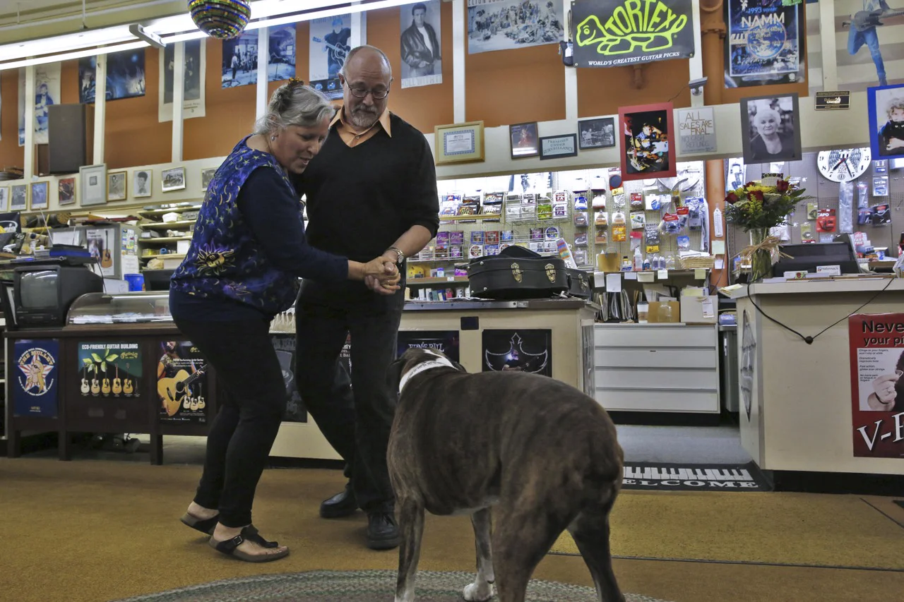  Cathy dances with her old friend Bill Roberts while her 9-year-old boxer, Haley, jealously tries to interrupt. Several musicians often gather in the store. This day they gave an impromptu concert. 