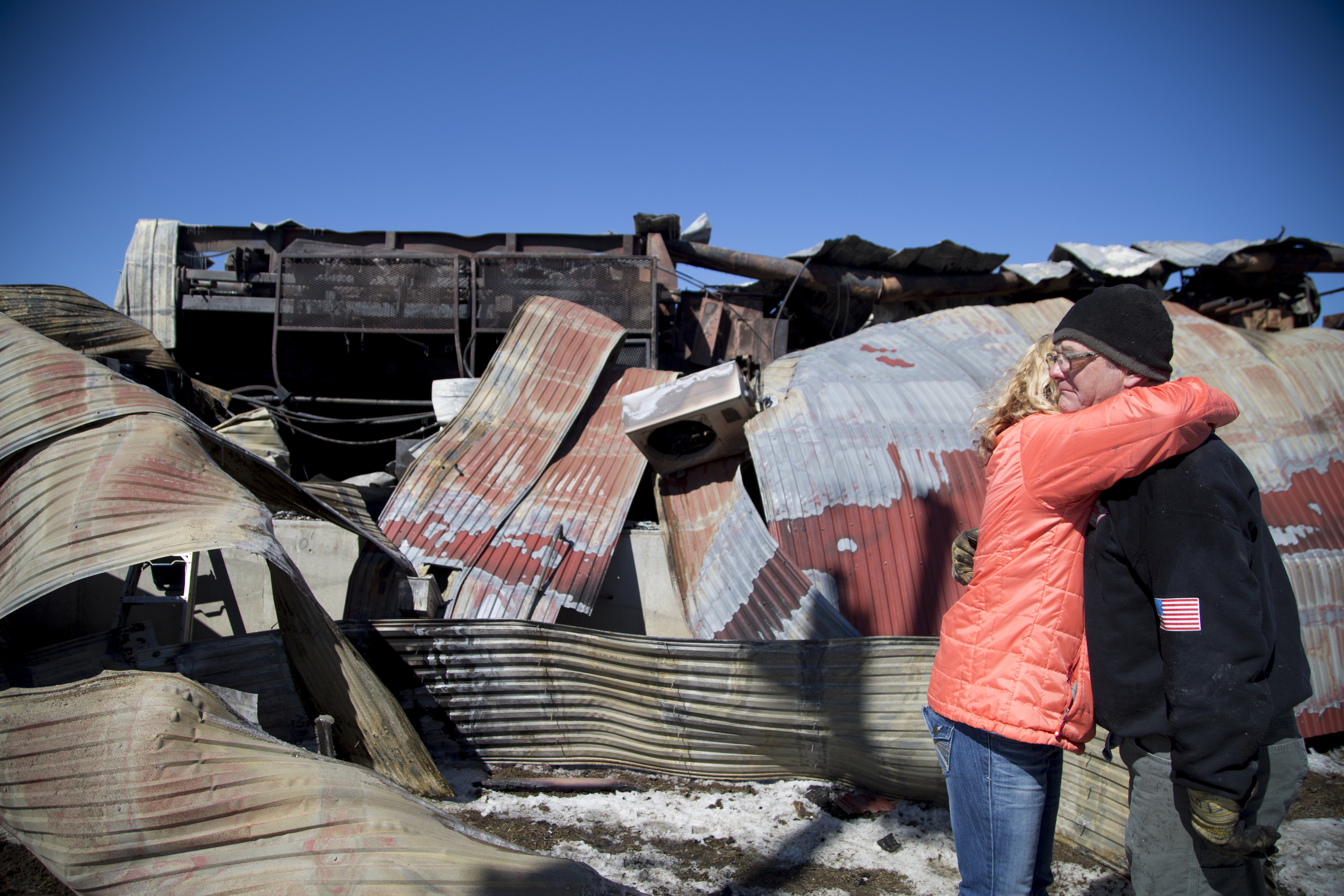 Safety and Permits Compliance Officer Becky Eastman, of Fairlee, Vt., embraces Sawmill Dry Kiln Manager Tom Fulton, also of Fairlee, Vt., by the remains of the sawmill building at Britton Lumber Company in Fairlee, Vt., on Sunday, March 29, 2015. "I