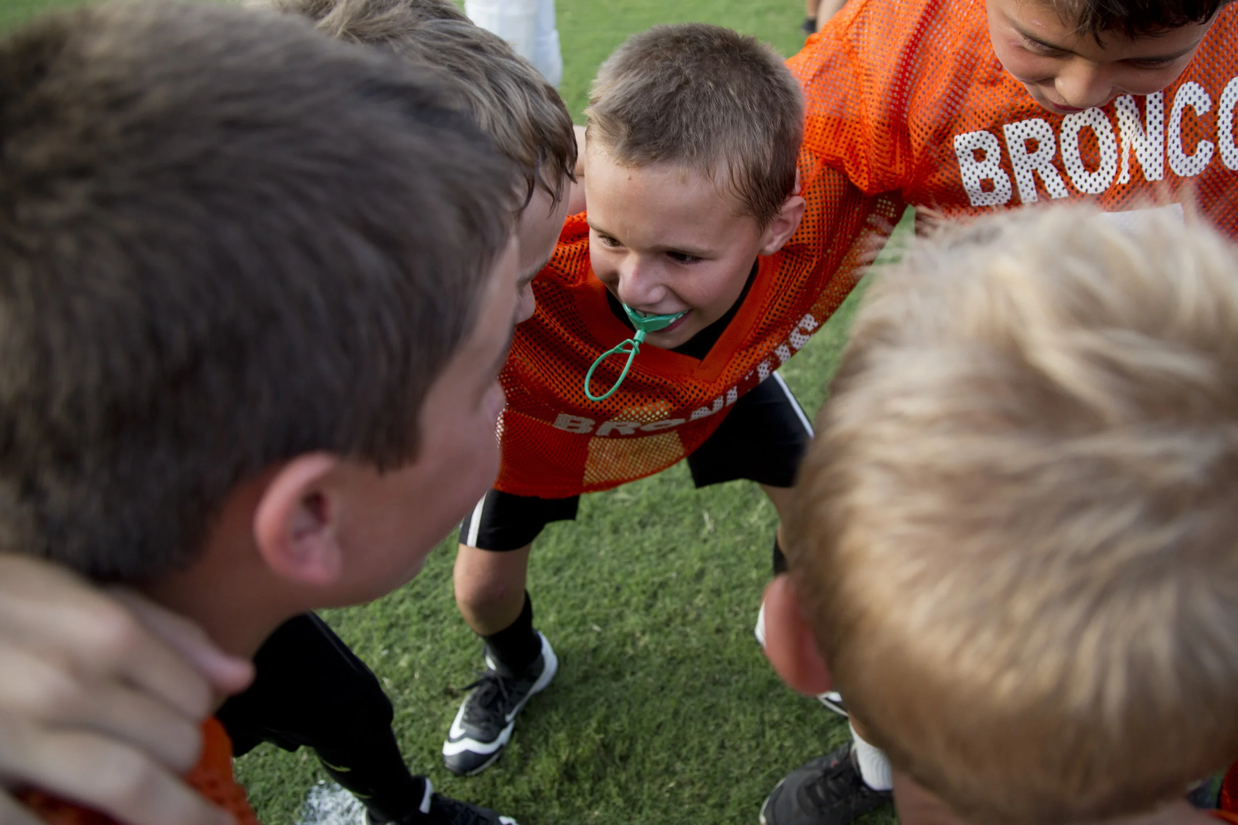 Kaden Meunier of Ferdinand, 9, center, huddled with his new Broncos teammates during SP&F Flag Football Draft Day at Ranger Field in Ferdinand on Wednesday. Over 50 second-, third-, and fourth-graders were drafted onto six different flag football teams.