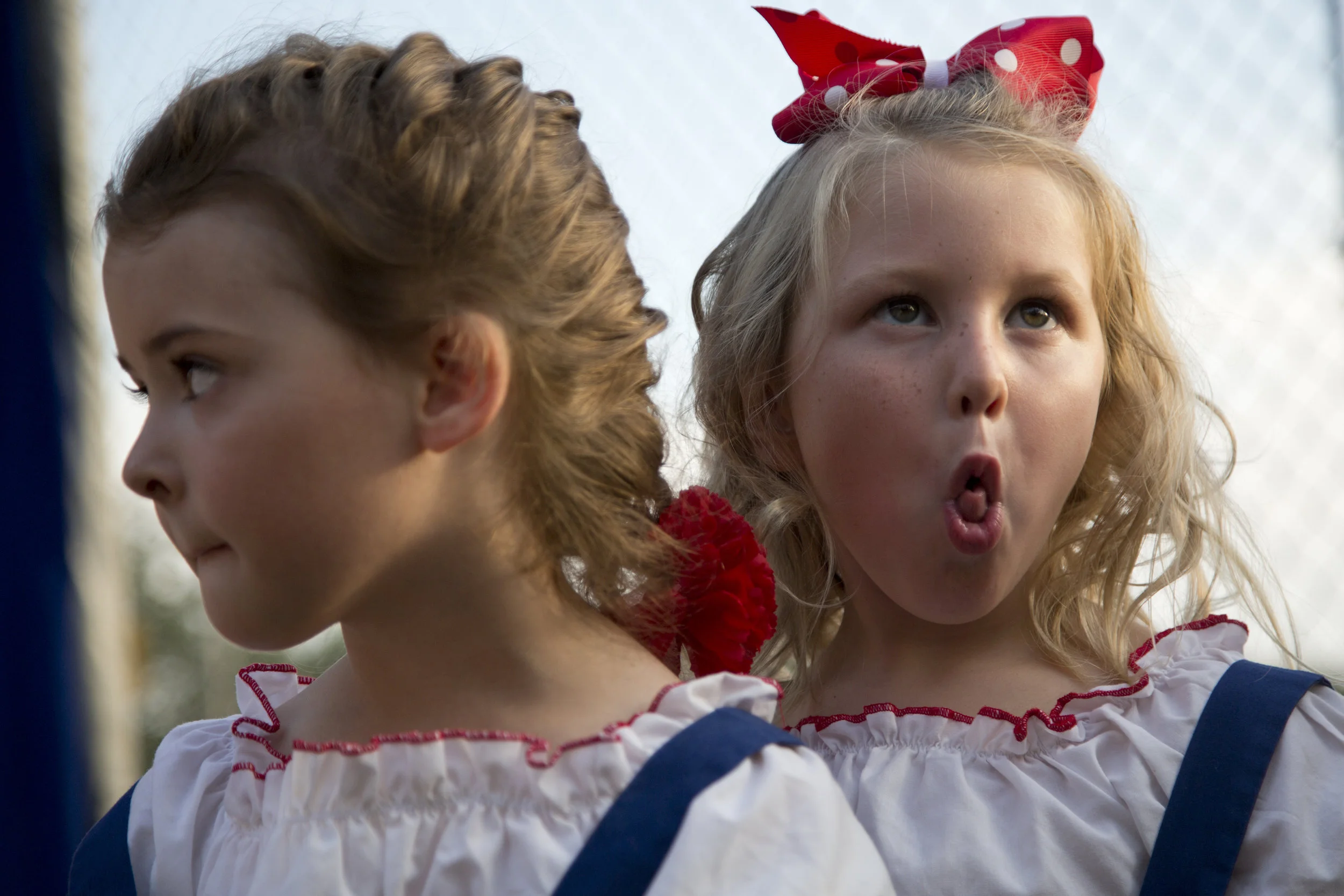 Piper Nichter of Huntingburg, 4, right, rolled her tongue while waiting in line with Madison Richardson of Holland, 5, for the Little Miss and Mister contest to begin during the Holland Community Fest in Holland on Friday. Several parent volunteers asked the girls to make funny faces to help calm their nerves. Piper then showed that she could roll her tongue. 