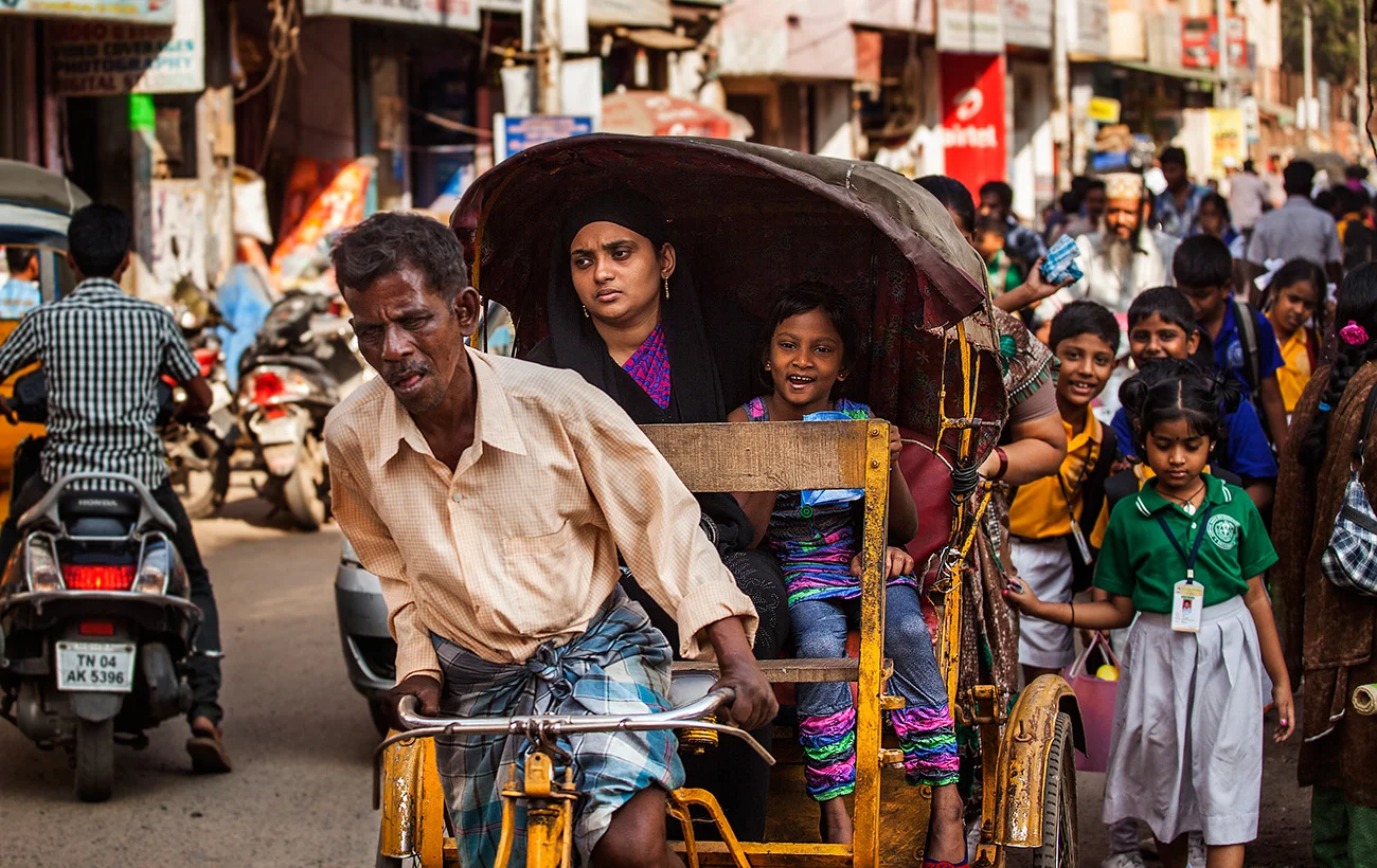Man working hard cycling his rickshaw