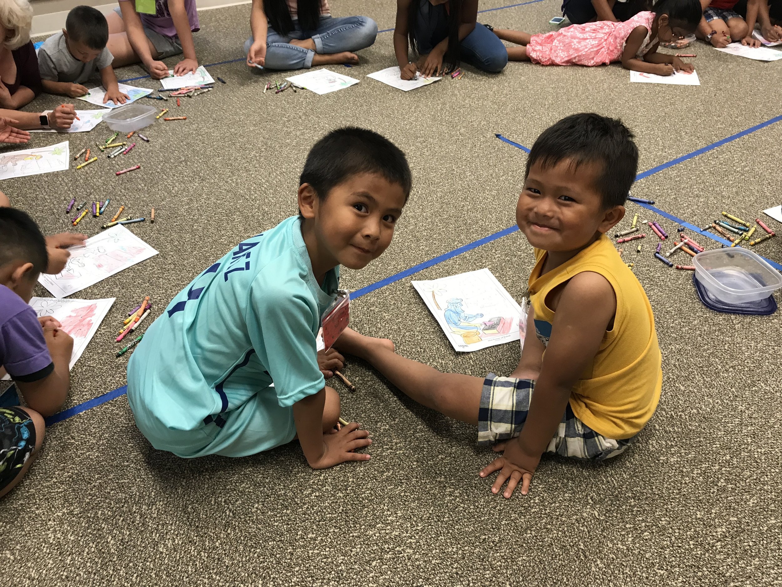 Pictured: A couple of our cute little students coloring at Refuge Kids Club.