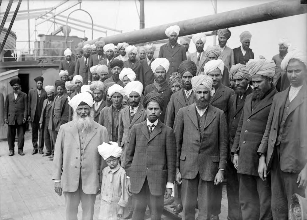 Gurdit Singh Sandhu (man in the left foreground, wearing a white turban) and passengers on board the Komagata Maru. 