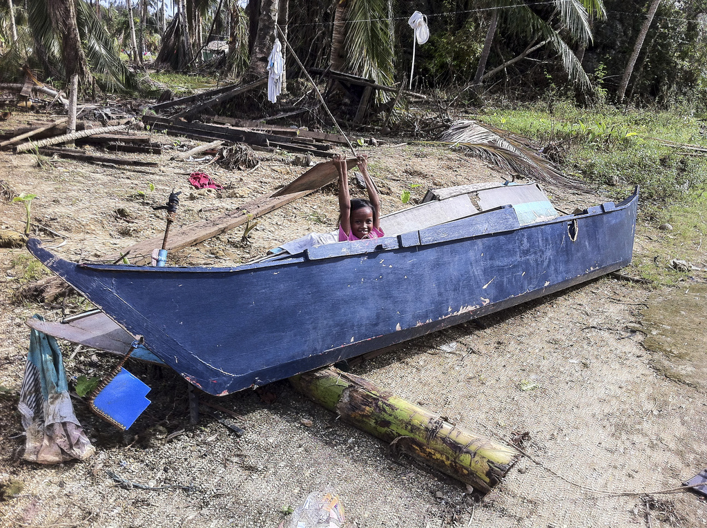 A Veloso girl plays in one of the many damaged fishing boats in town. Typhoon Haiyan not only destroyed houses and crops, it left many of the region's fishermen without viable means of income. 