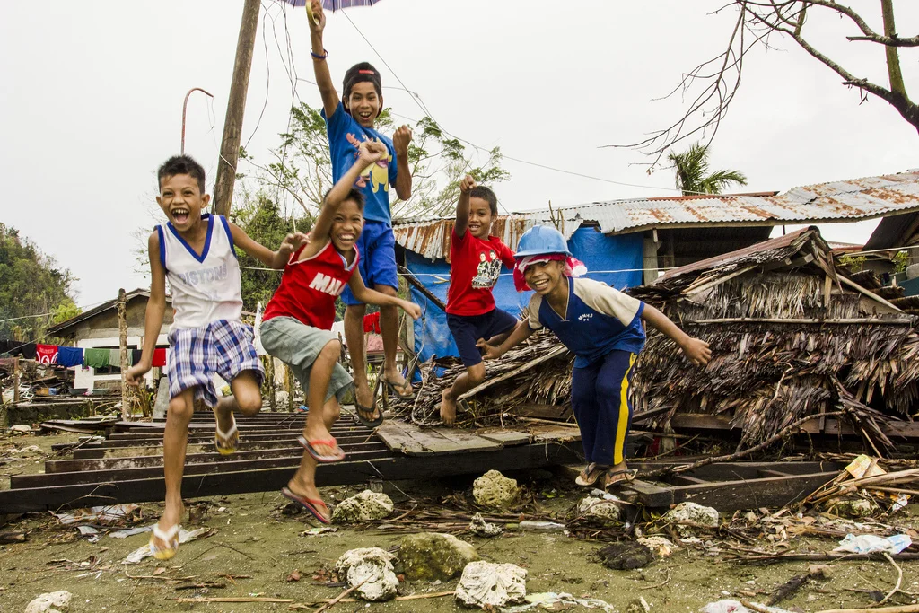 Boys jump from the flattened remains of a seaside house in their village, Veloso, in Samar. 