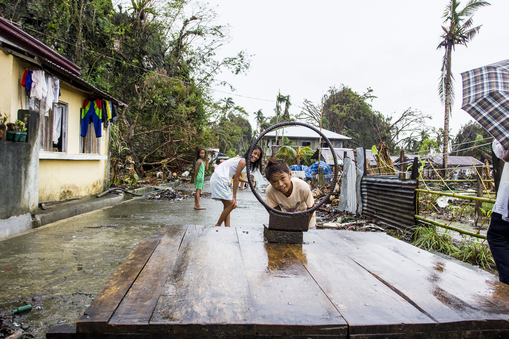 Eriko, a boy from Veloso, a town in Samar province hit heavily by Typhoon Haiyan, peers through the remains of one of the town basketball rings.