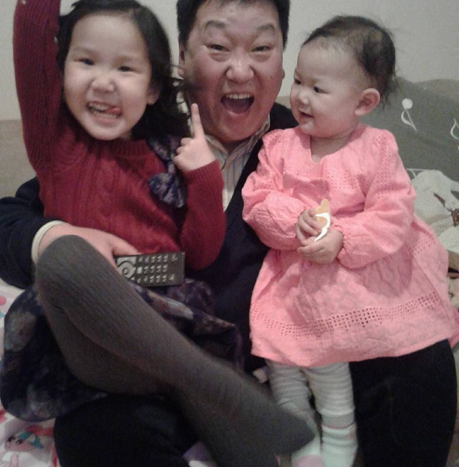 Jargal's recovery from alcoholism has allowed him and his family to seek forgiveness with each other. Here, he plays with his granddaughters.