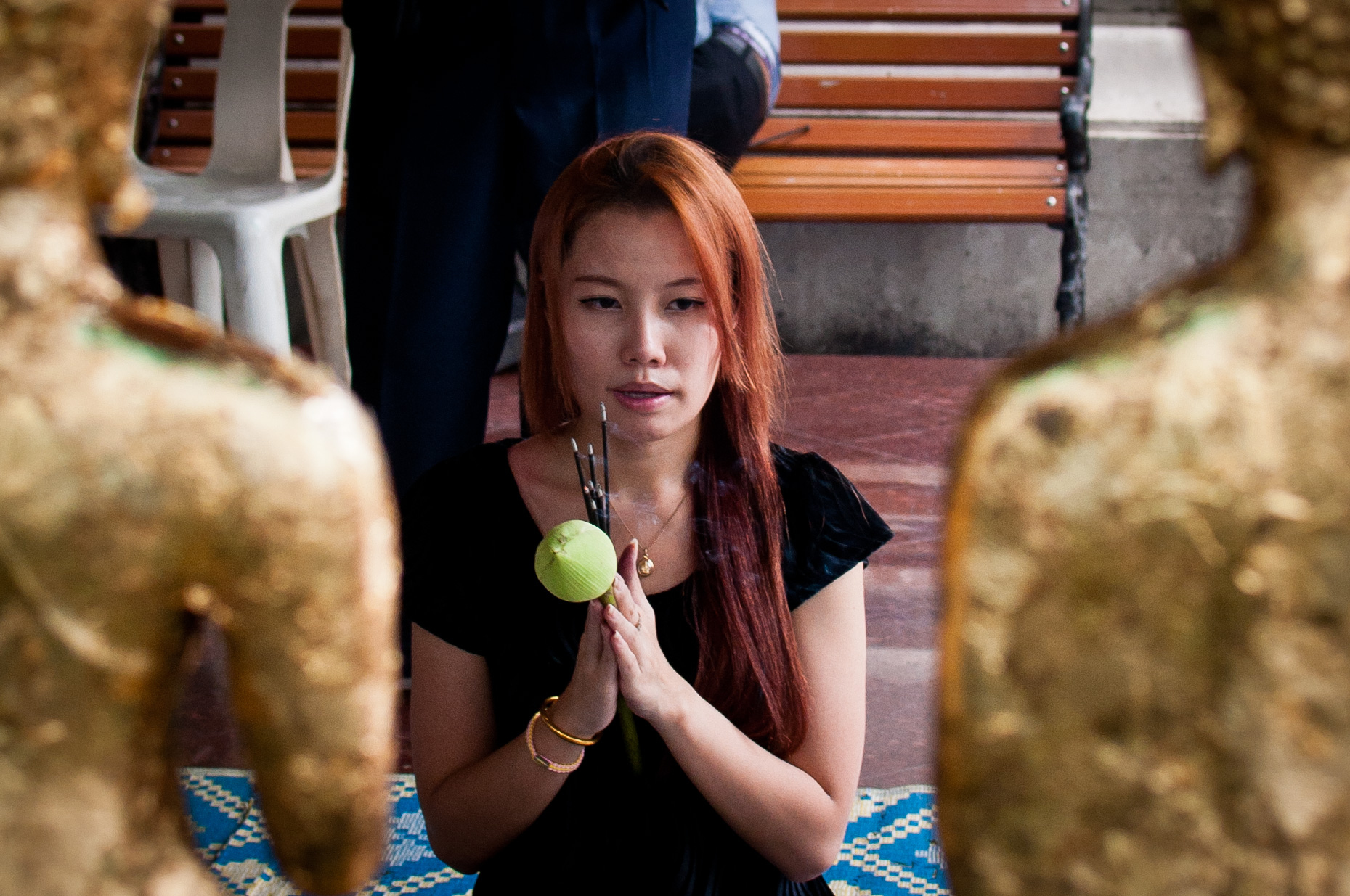 A woman prays and offers incense at Wat Pho in Bangkok. Most of Prang's family is still Buddhist and take issue with Prang becoming a Christian. Photo courtesy of Mark Fischer . 