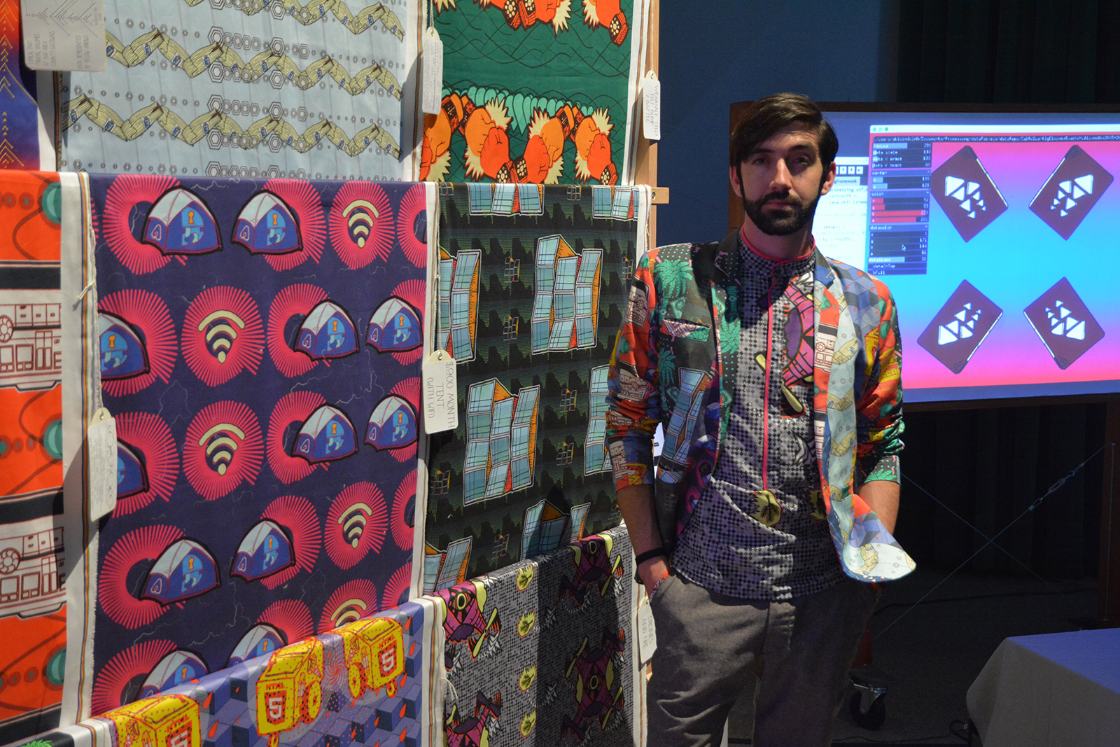 Sam B. models outfit design by Timothy Ho in front of fabric installation and demo video.