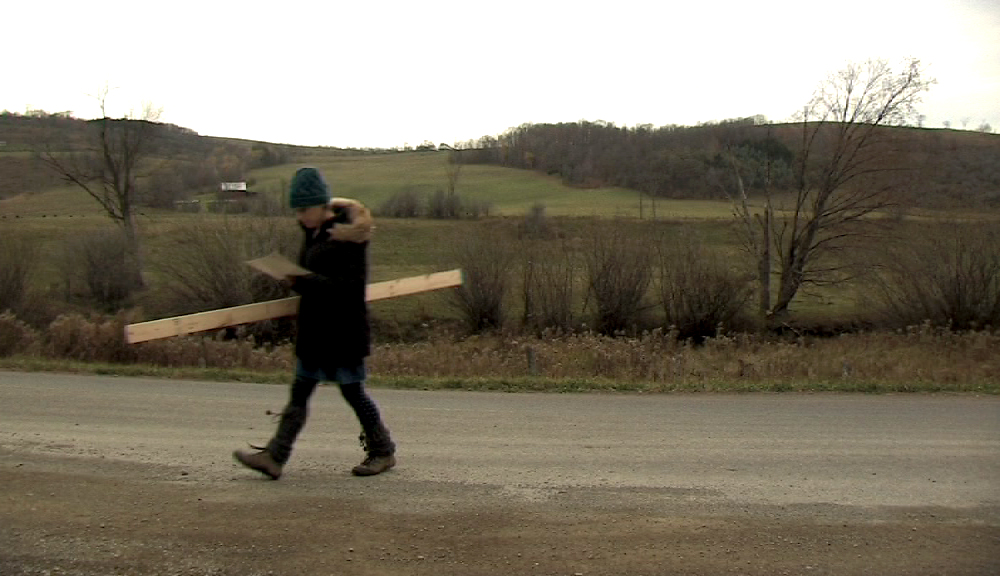  re-enacting carrying planks to the barn (first of three men) 