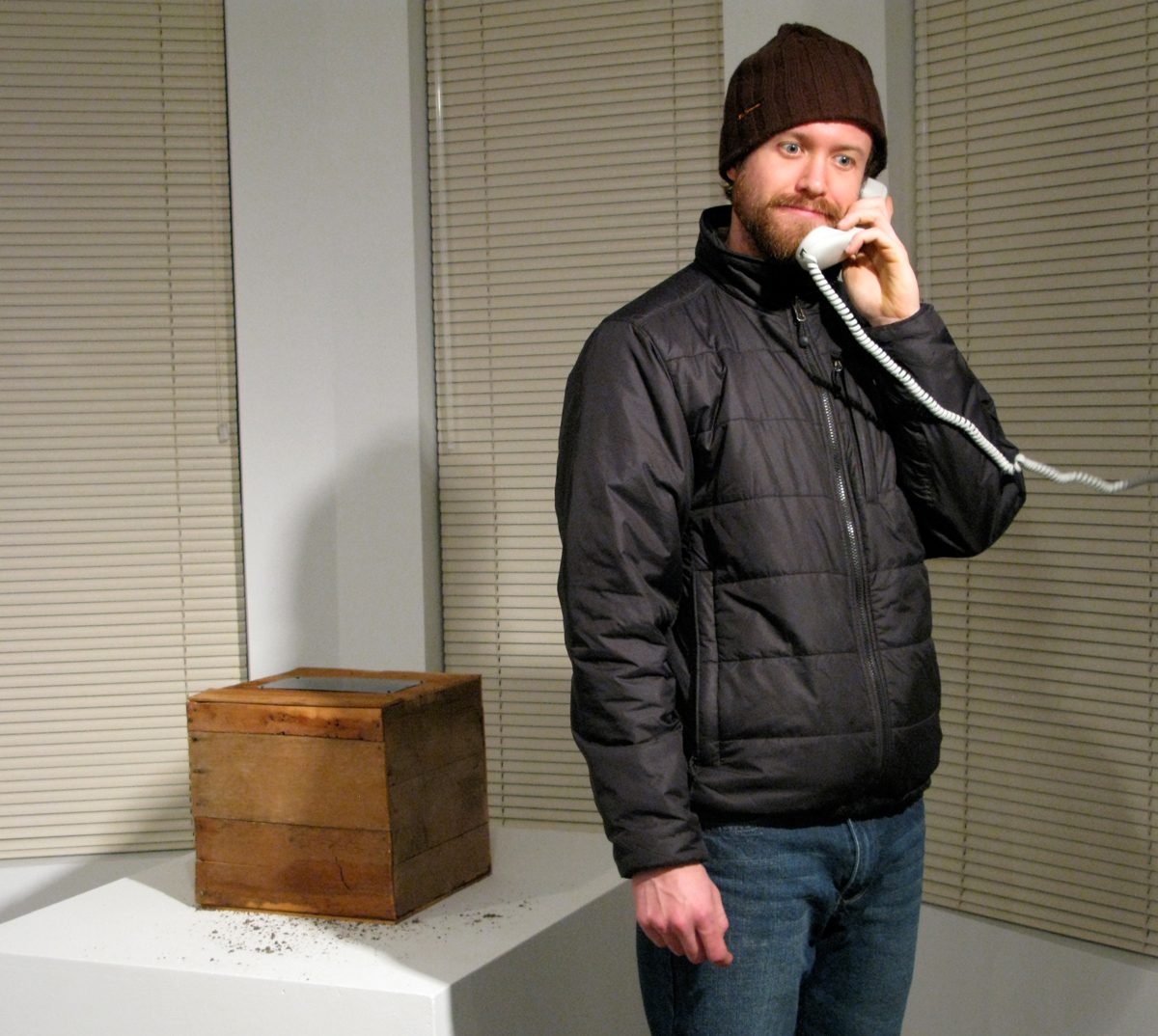  a man telephoning the time capsule to leave a message on the mobile phone inside 