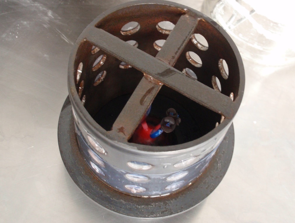   A steel flask is secured over the base, with a tree of ring models inside.  