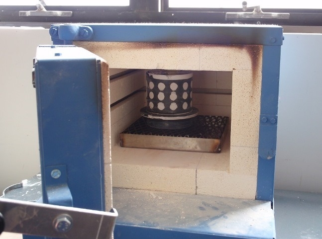   The flask is placed in a kiln for a 10-hour burnout. A steel wax tray collects the wax from the mold, leaving behind a hollow space for each model.  